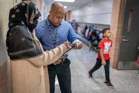 Gideon Pond Elementary social worker Abdullahi Khalif, right, consulted with a parent in her native Somali language Friday at the school in Burnsville