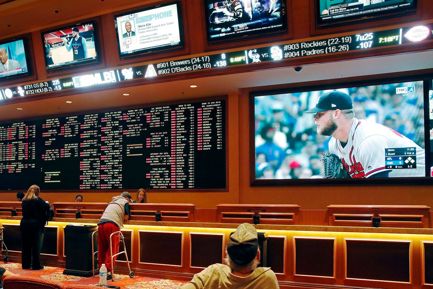 FILE - In this Monday, May 14, 2018 file photo, people make bets in the sports book area of the South Point Hotel and Casino in Las Vegas. Those who deal with compulsive gambling are worried that a rapid expansion of sports betting in the U.S. could cause more people to develop gambling problems. The U.S. Supreme Court on Monday cleared the way for states to legalize sports betting.