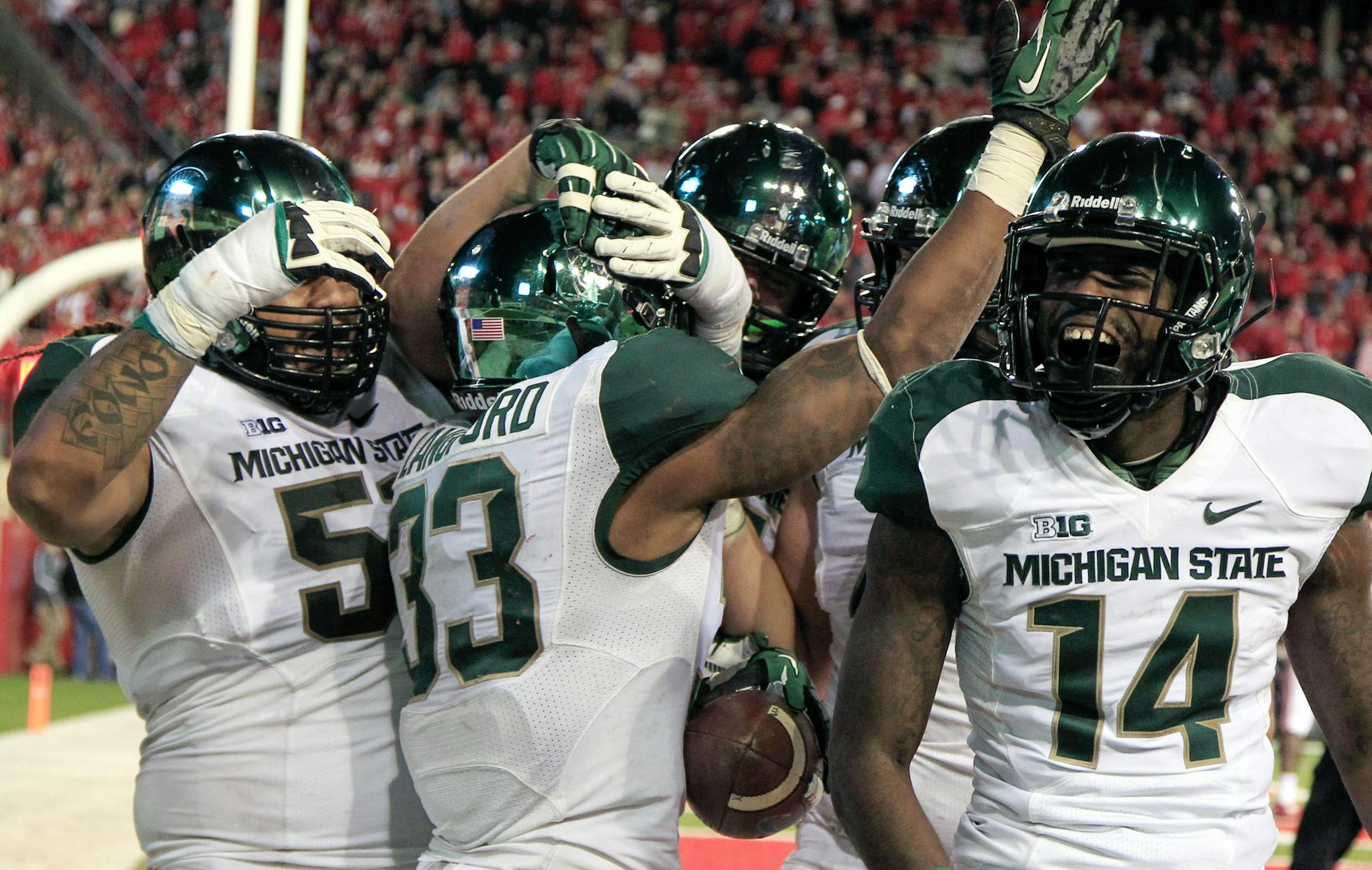 Michigan State running back Jeremy Langford (33) celebrates with teammates, including tackle Fou Fonoti, left, and wide receiver Tony Lippett (14), after scoring a touchdown against Nebraska in the second half of an NCAA college football game in Lincoln, Neb., Saturday, Nov. 16, 2013. Michigan State won 41-28. (AP Photo/Nati Harnik)