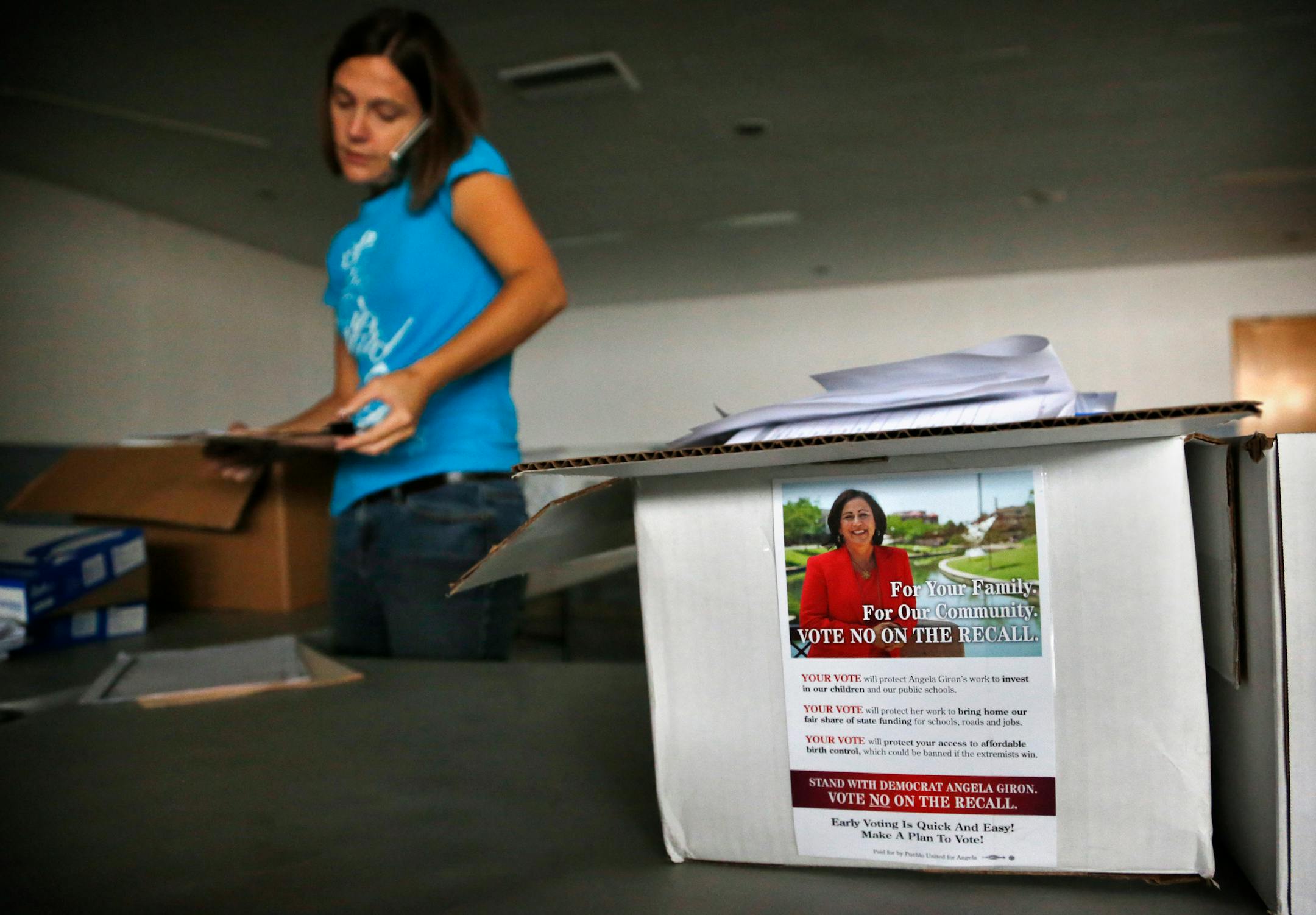 A campaign volunteer talks on the phone as she and others pack up before vacating a union hall used as a canvassing headquarters for Democratic state Sen. Angela Giron, one day after a recall vote which Giron lost, in Pueblo, Colo., Wednesday Sept. 11, 2013. Two Colorado state lawmakers who backed gun-control measures in the aftermath of the mass shootings in Colorado and Connecticut last year were ousted Tuesday in recall elections. (AP Photo/Brennan Linsley)