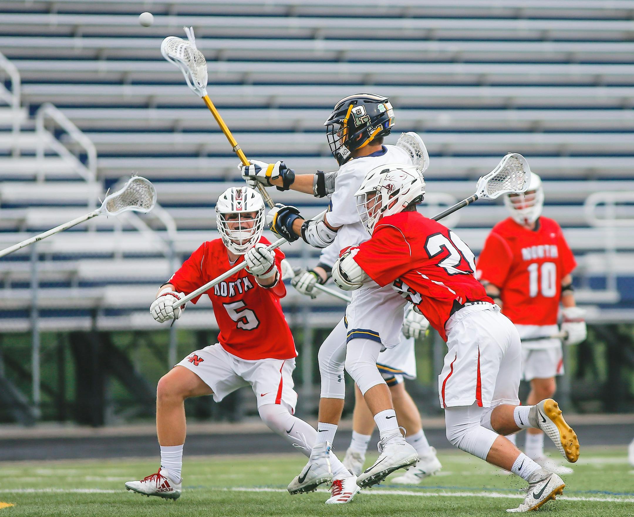 Prior Lake's Bennet Holst scored over Lakeville North defenders Charlie Dickie (5) and Vinny Zuelsdorff in the first half of the Lakers' 13-7 boys' lacrosse state tournament quarterfinal victory Tuesday, June 12, 2018, at Chanhassen High School. Photo by Mark Hvidsten, SportsEngine