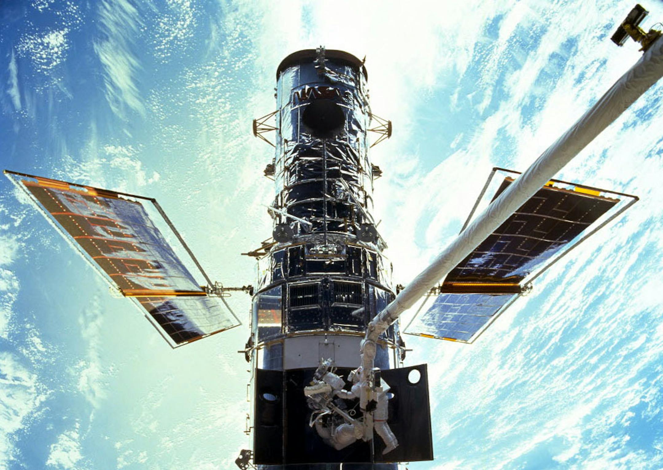 In this image provided by NASA/JSC, astronauts Steven L. Smith and John M. Grunsfeld are photographed during an extravehicular activity (EVA) during the December 1999 Hubble servicing mission of STS-103, flown by Discovery. The Hubble Space Telescope, one of NASA'S crowning glories, marks its 25th anniversary on Friday, April 24, 2015. With more than 1 million observations, including those of the farthest and oldest galaxies ever beholden by humanity, no man-made satellite has touched as many mi