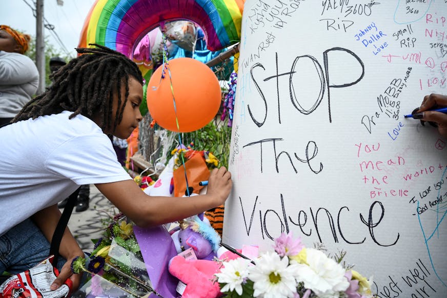 Camron Smith, 8, signed a sign at the memorial for Aniya Allen Wednesday night. Camron is the brother of Trinity Ottoson-Smith, the 9-year old girl shot in the head Saturday night.