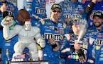 Kyle Busch, front right, celebrates in Victory Lane after winning a NASCAR Cup series auto race, Sunday, Oct. 1, 2017, at Dover International Speedway