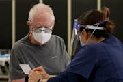 A man reads information after receiving the coronavirus vaccine at a vaccine center in Santa Barbara, Calif., Jan. 26, 2021. 
