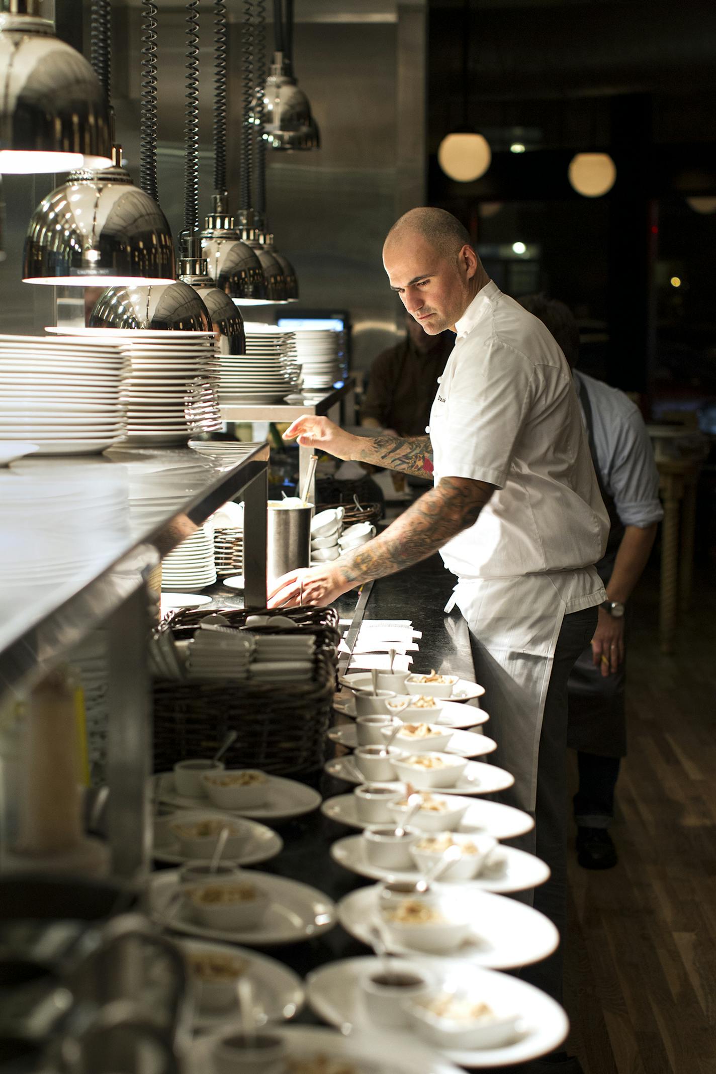 Executive chef Daniel del Prado preps plates to be served with steaks at Burch Steakhouse and Pizza Bar December 13, 2013. (Courtney Perry/Special to the Star Tribune)