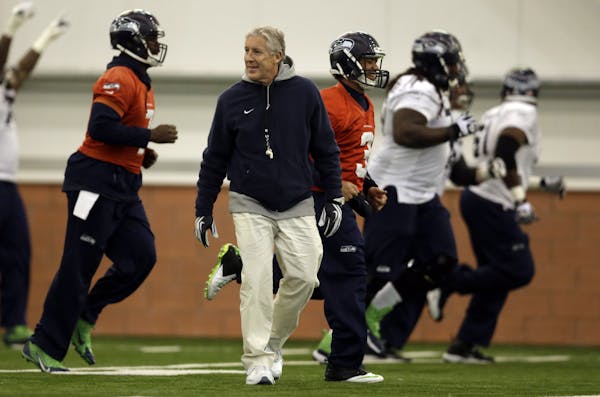 Seattle Seahawks head coach Pete Carroll watches as members of his team warms up during NFL football practice Thursday, Jan. 30, 2014, in East Rutherf