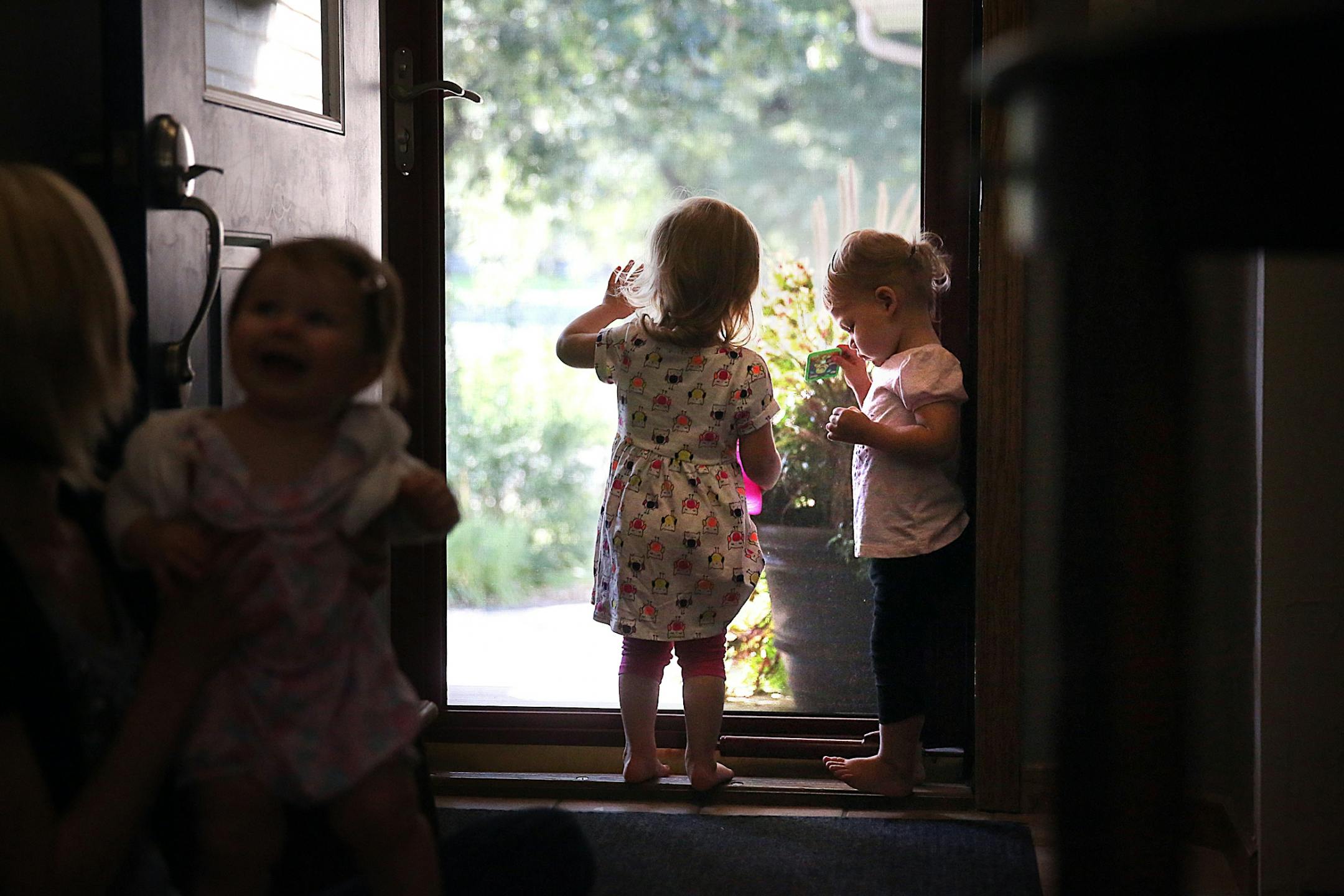 Sable Gass� daughter, Louella, 20 months (middle), peered out a door. At right is Susan Stone�s daughter, Collin, almost 2.