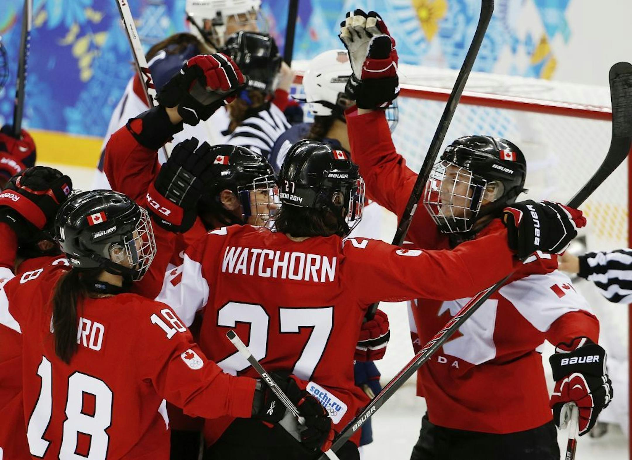 Hayley Wickenheiser of Canada, right, celebrates with her teammates after her goal against the Unites States during the third period of the 2014 Winter Olympics women's ice hockey game at Shayba Arena, Wednesday, Feb. 12, 2014, in Sochi, Russia.