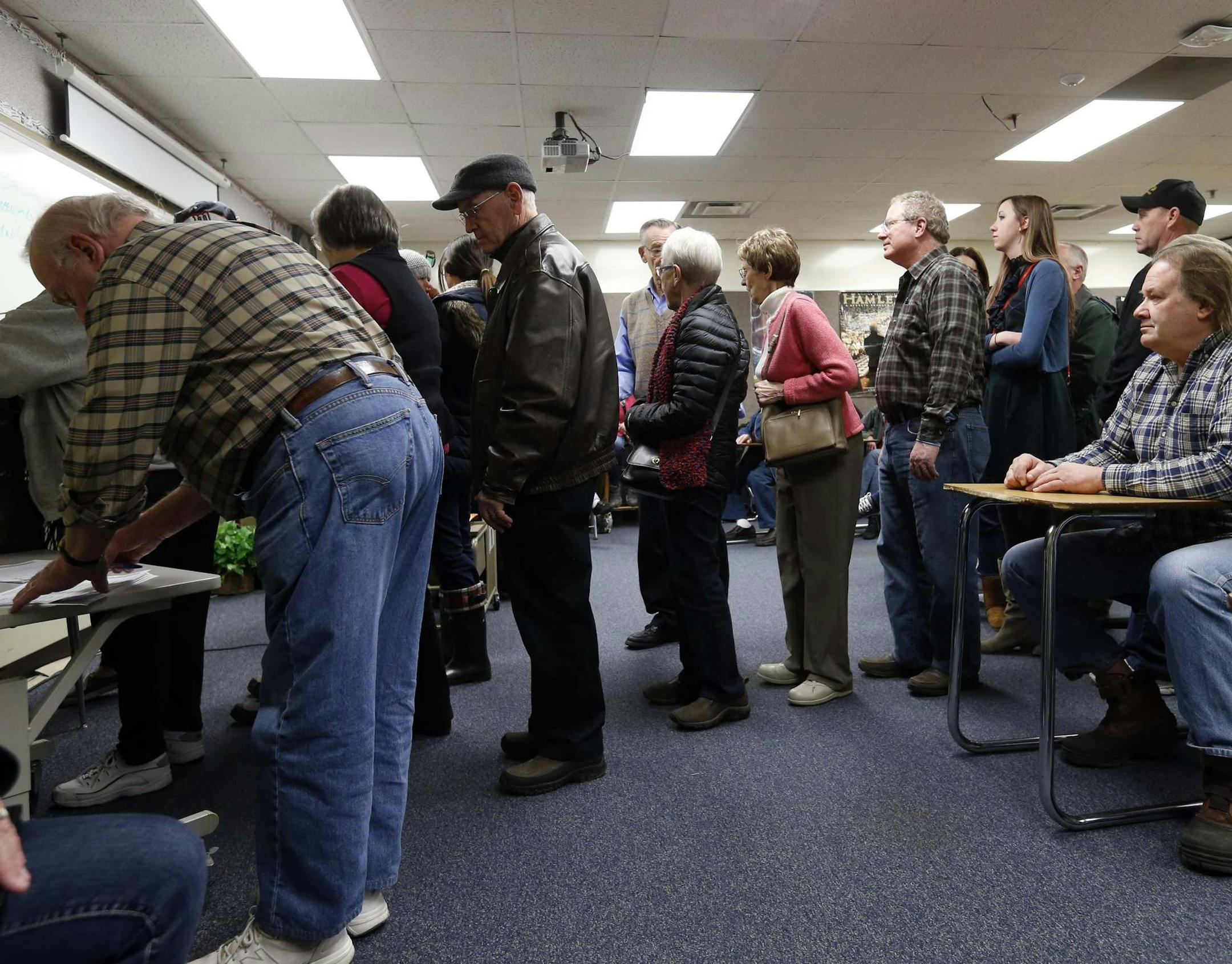 FILE - In this March 1, 2016 file photo, Republicans register in their precinct as they caucus at Bloomington Jefferson High School in Bloomington, Minn. Minnesota's political caucuses are likely to be far less rowdy this year _ and far less crowded than in the past. That's because the state has shifted its presidential preference process away from caucuses and into a primary election that's part of Super Tuesday next month. (AP Photo/Jim Mone File)