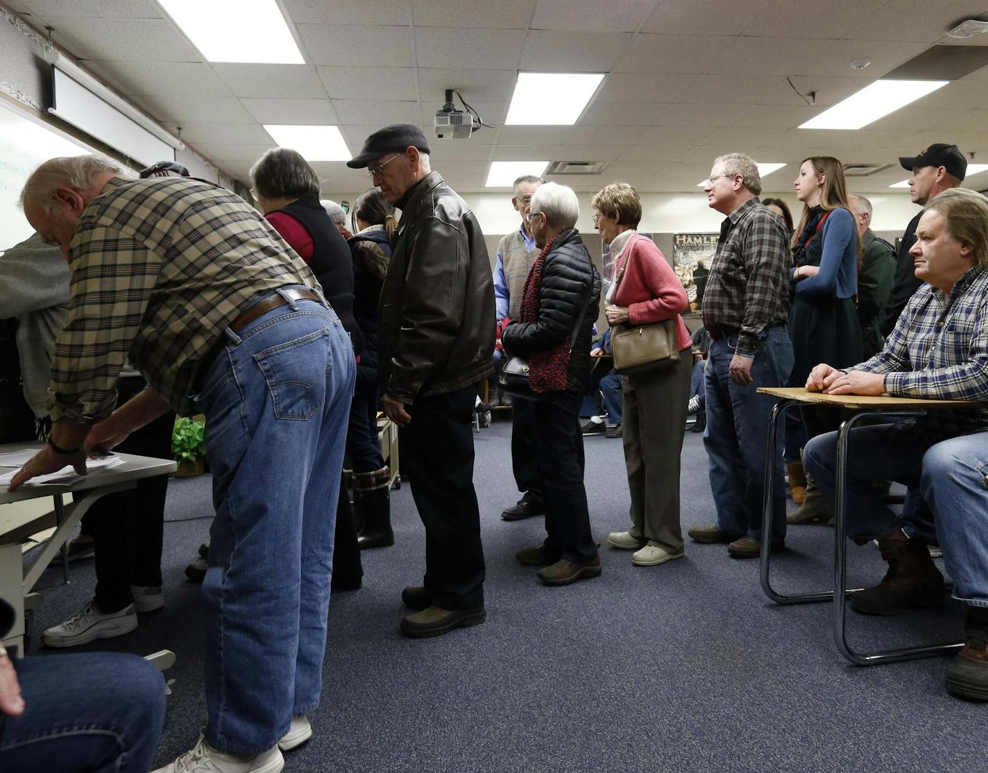 FILE - In this March 1, 2016 file photo, Republicans register in their precinct as they caucus at Bloomington Jefferson High School in Bloomington, Minn. Minnesota's political caucuses are likely to be far less rowdy this year _ and far less crowded than in the past. That's because the state has shifted its presidential preference process away from caucuses and into a primary election that's part of Super Tuesday next month. (AP Photo/Jim Mone File)