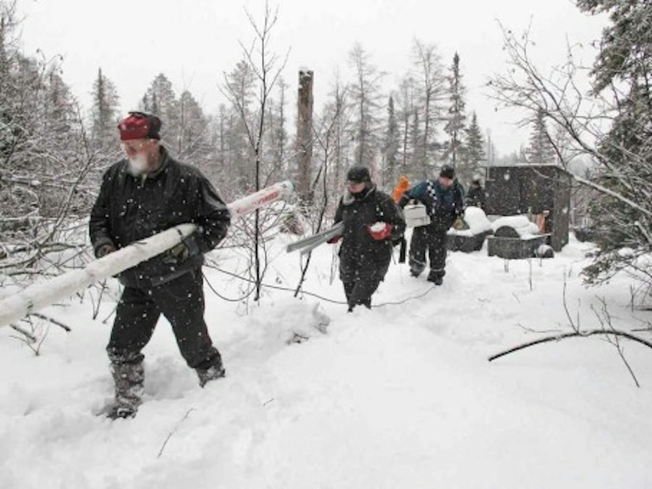 Bear researcher Lynn Rogers, foreground, with a group of volunteers on Dec. 30 setting up a tiny camera inside a bear den near Ely, the winter home of "Lily'' and her yearling cub, "Hope.''