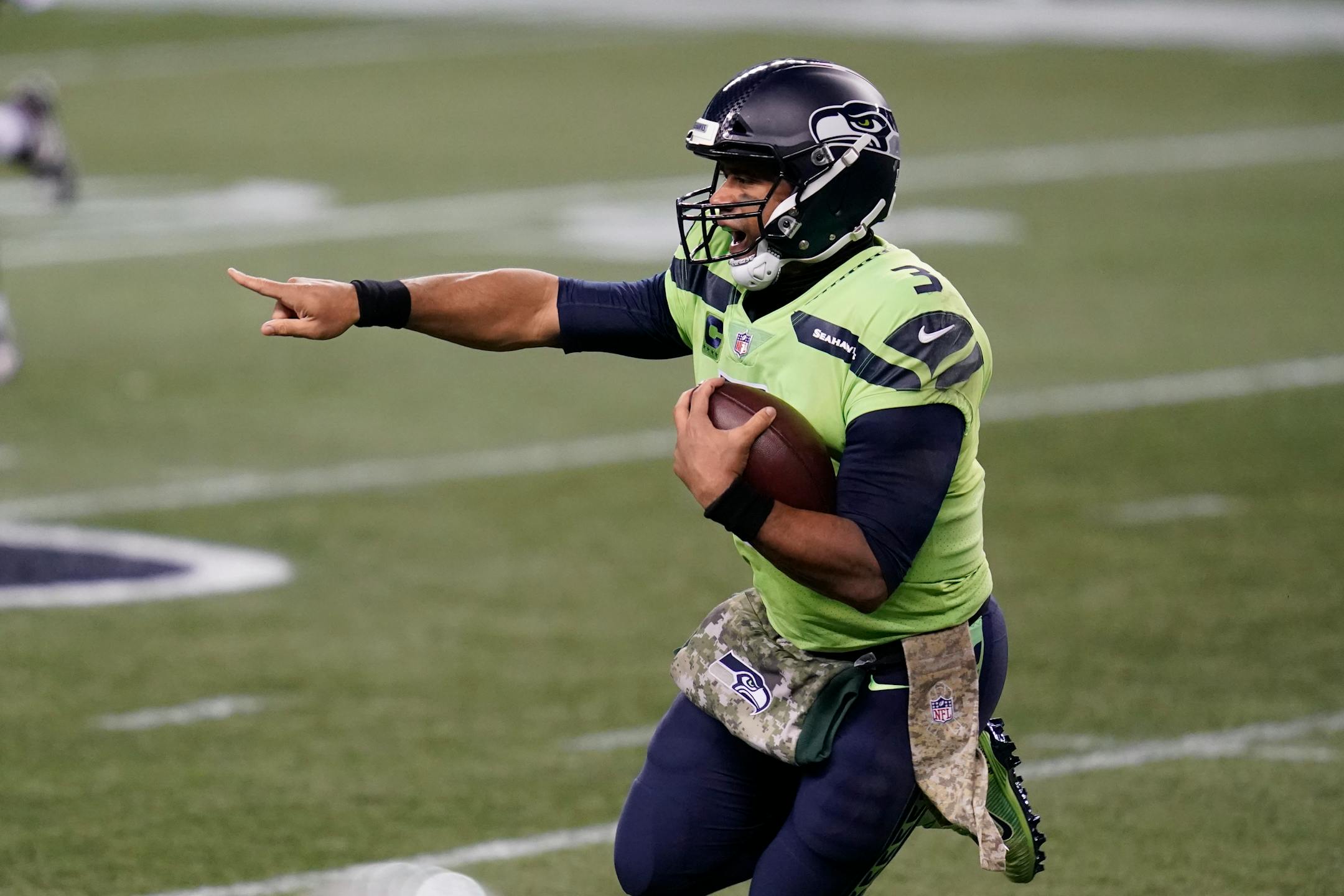 Seahawks quarterback Russell Wilson gestures as he scrambles against the Cardinals during the first half
