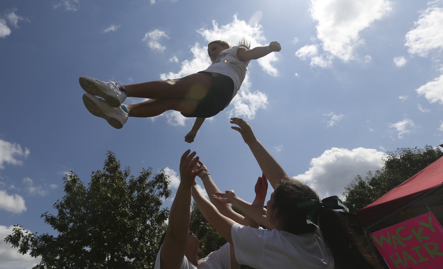 Morgan Reibly a sophomore at Rosemount High School, prepared to be caught by her cheerleading teammates as they try to drum up customers for the their wacky hair booth at the Leprechaun Days in Rosemount, Min., Saturday, July 28, 2012. ] (KYNDELL HARKNESS/STAR TRIBUNE) kyndell.harkness@startribune.com