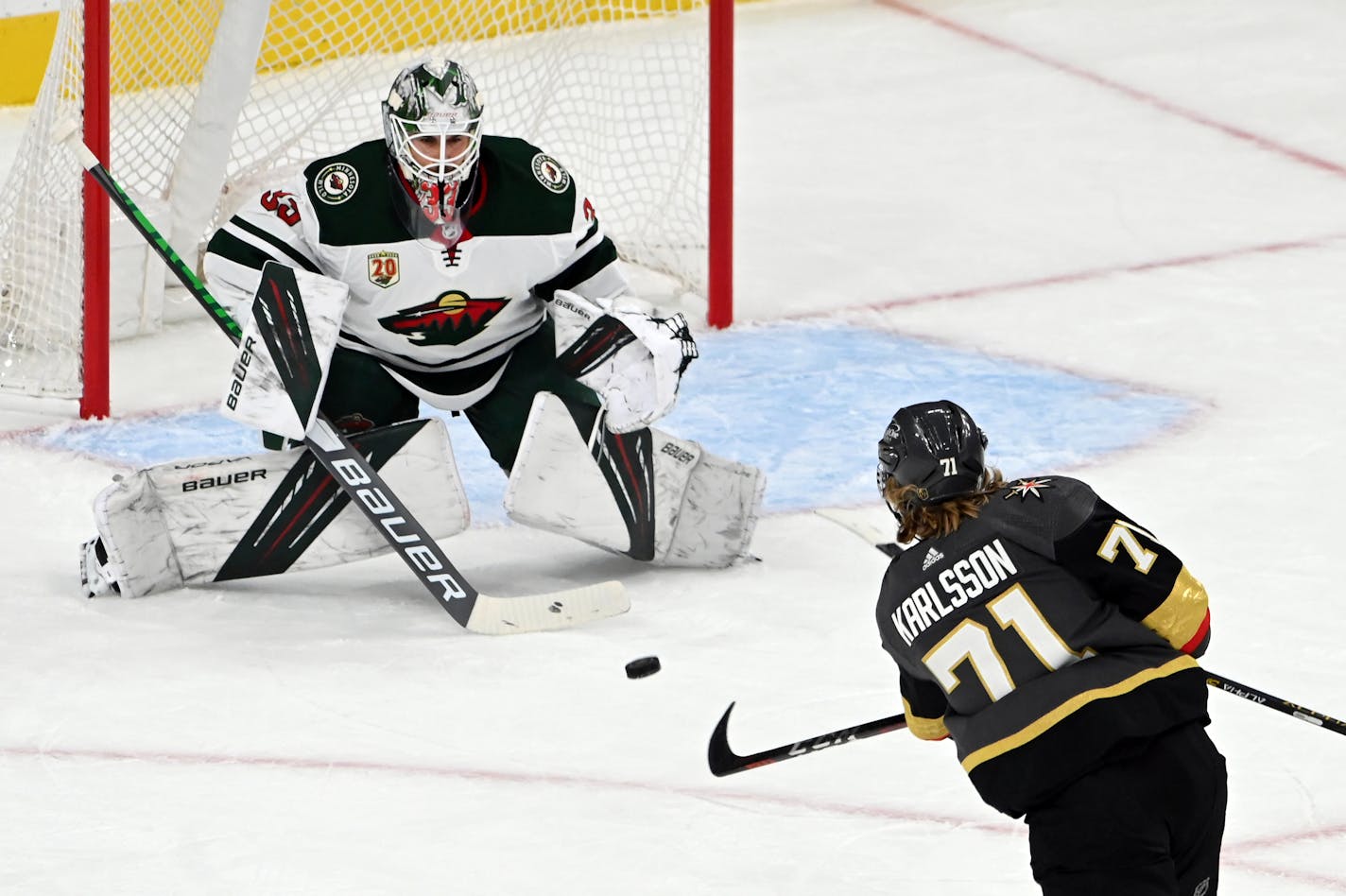 Vegas Golden Knights center William Karlsson (71) takes a shot on goal against Minnesota Wild goaltender Cam Talbot (33) during the first period of Game 1 of a first-round NHL hockey playoff series Sunday, May 16, 2021, in Las Vegas. (AP Photo/David Becker)