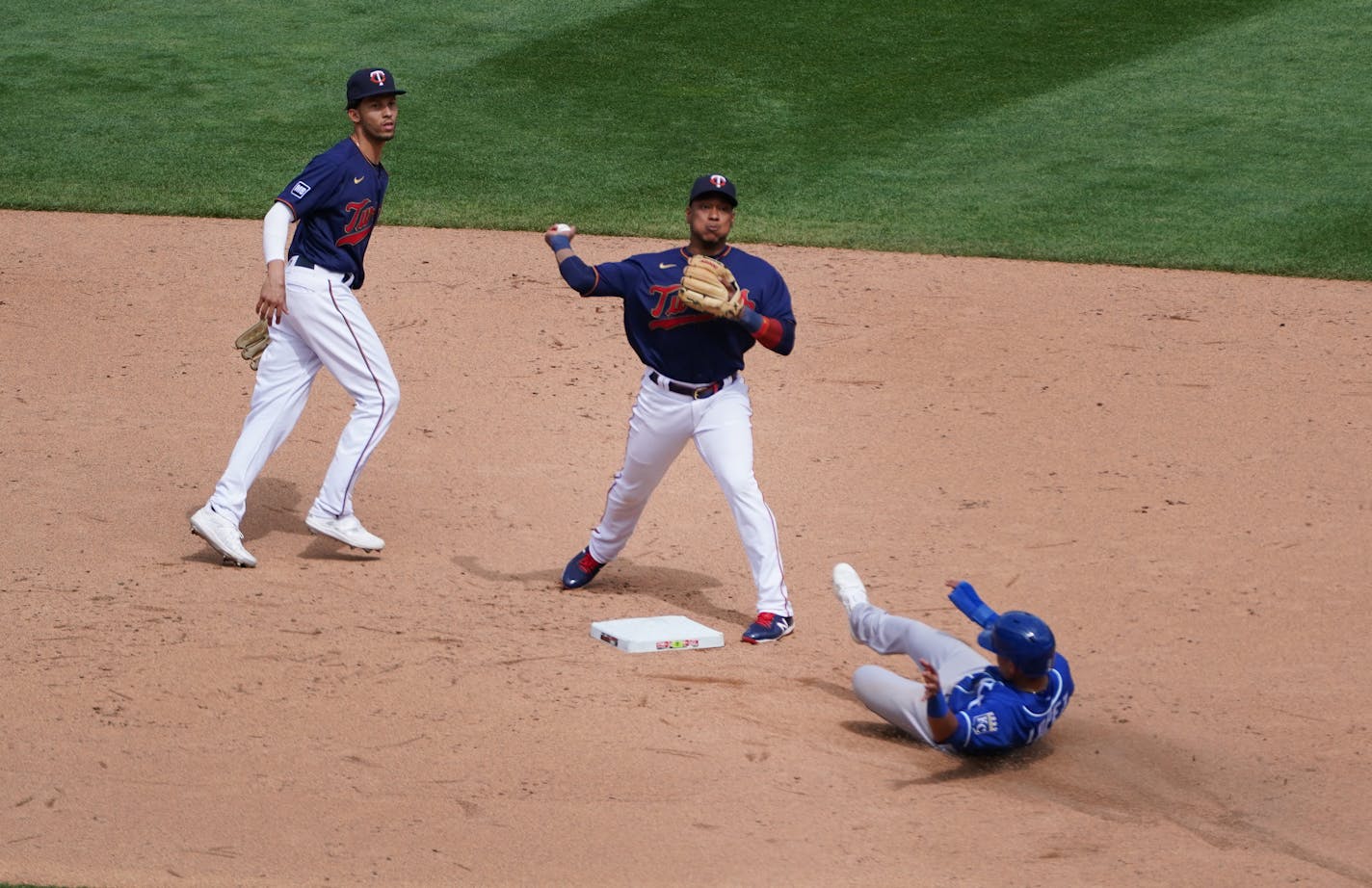 Kansas City Royals second baseman Nicky Lopez (8) slid into second base as Minnesota Twins shortstop Andrelton Simmons (9) and shortstop Jorge Polanco (11) turned a double play in the sixth inning.