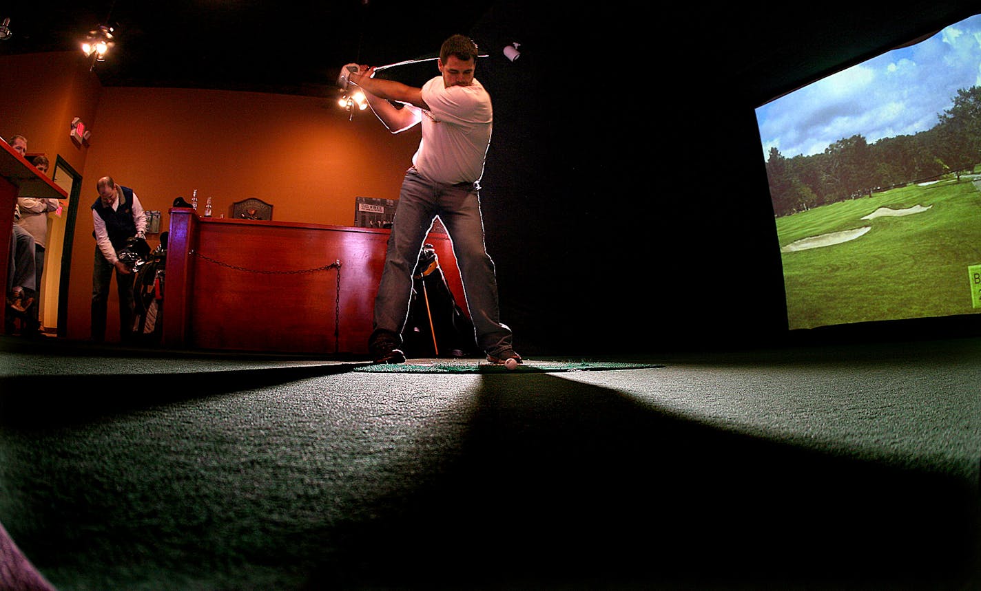 Brett Anderson, Ft. Collins, Colorado, prepared to take a shot while playing a round of simulated golf with friends at Digital Links Indoor Golf Simulator in Hastings. Players hit the ball at a screen that simulates various golf courses, in this case Pebble Beach Golf Links Golf Course.