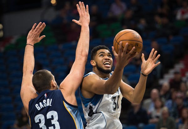 Timberwolves forward Karl-Anthony Towns (32) scored a layup under the defense of Memphis Grizzlies center Marc Gasol