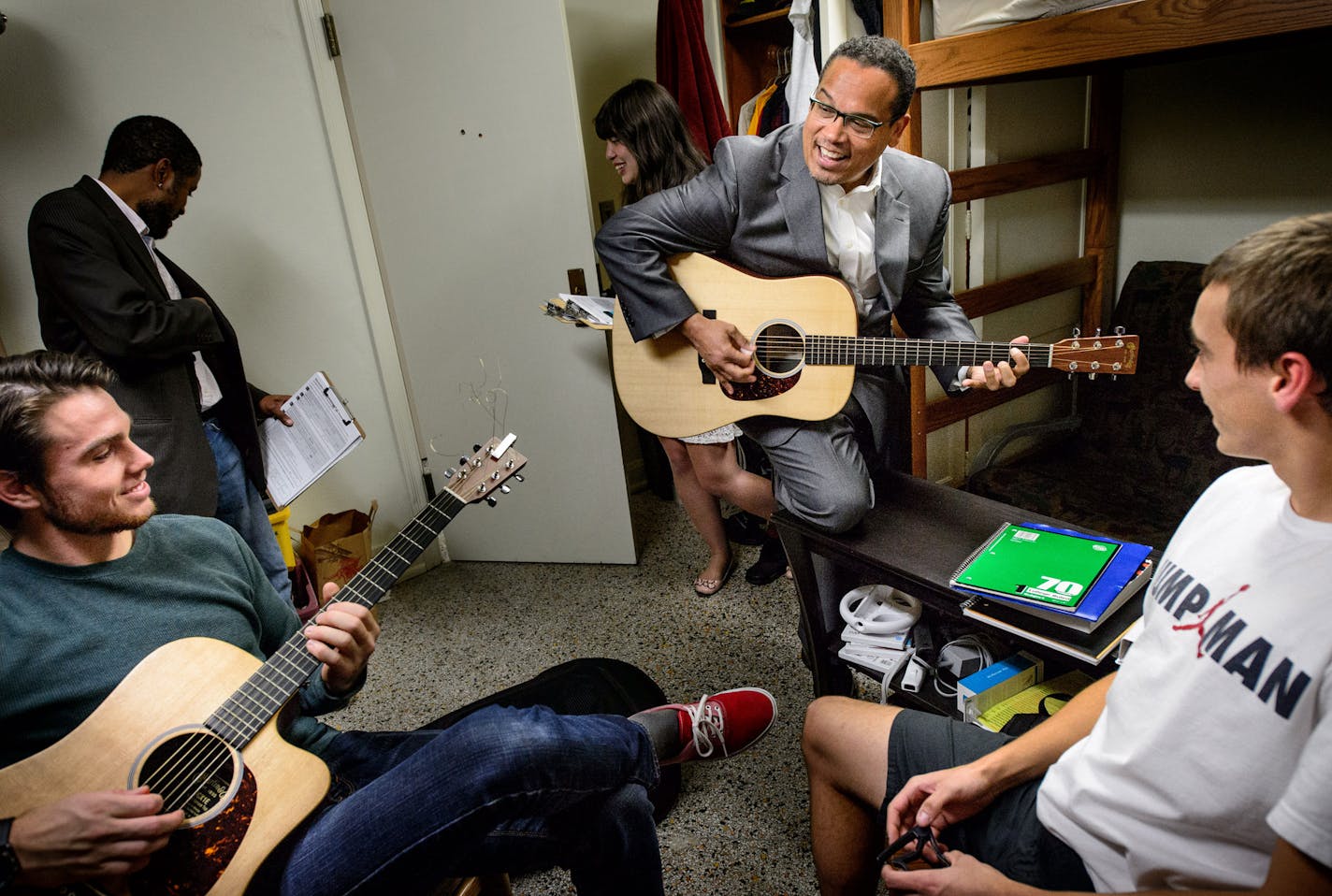 Rep Keith Ellison pulled a fresh pick out of his pocket and launched into a rocking version of Johnny B. Goode when freshman Aaron Stein, right, handed his guitar to Ellison. Stein and Seth Blum, left, are from Hudson, Wisconsin and said they both planned to travel home to vote on election day. ] GLEN STUBBE * gstubbe@startribune.com Rep. Keith Ellison went door knocking with around 20 college Democrats in Pioneer Hall Dorm at the University of Minnesota, Minneapolis, to sign up new voters. Wedn