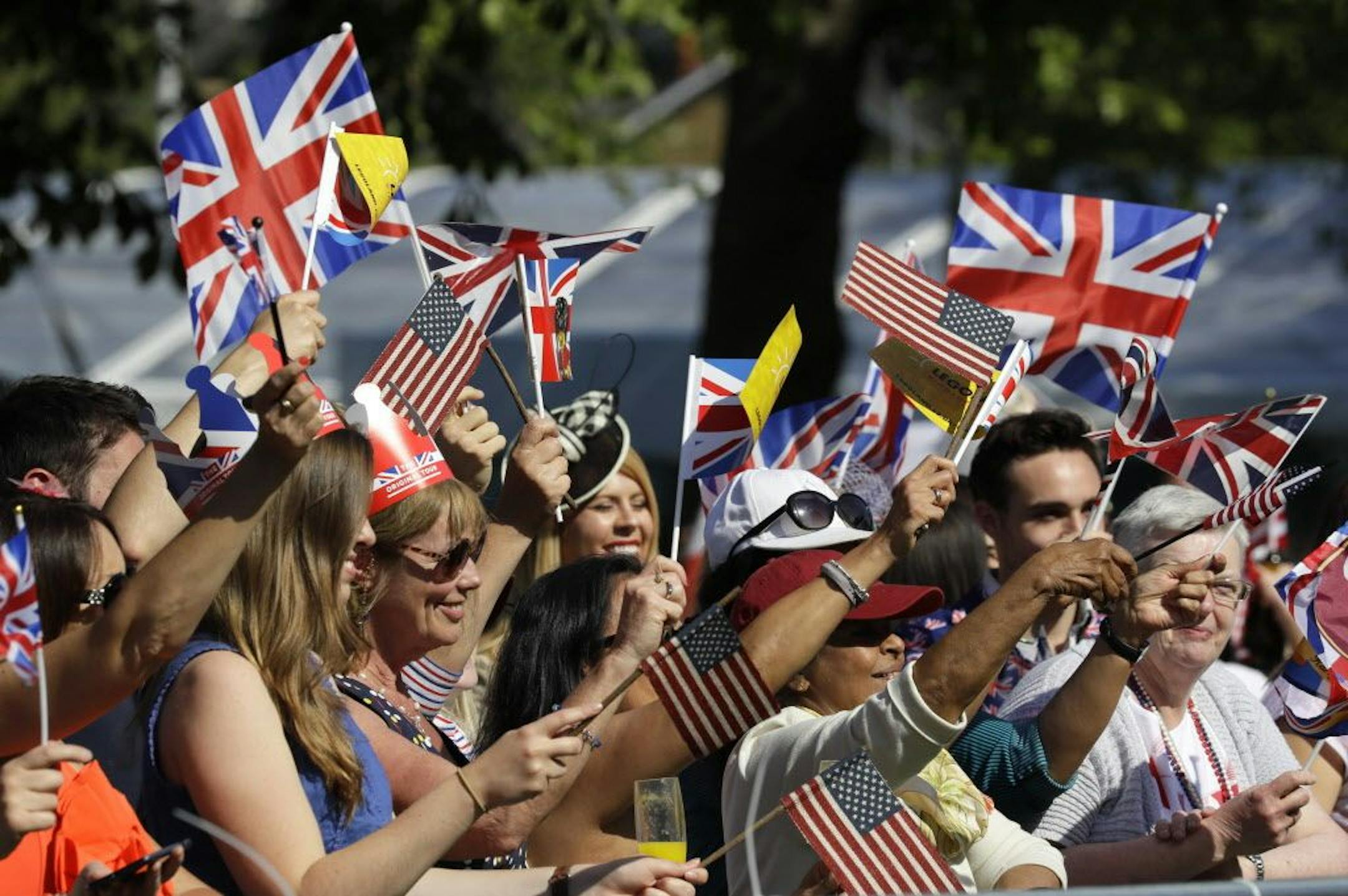 Well-wishers wave British and American flags prior to the wedding ceremony of Prince Harry and Meghan Markle at St. George's Chapel in Windsor Castle in Windsor, near London, England, Saturday, May 19, 2018.