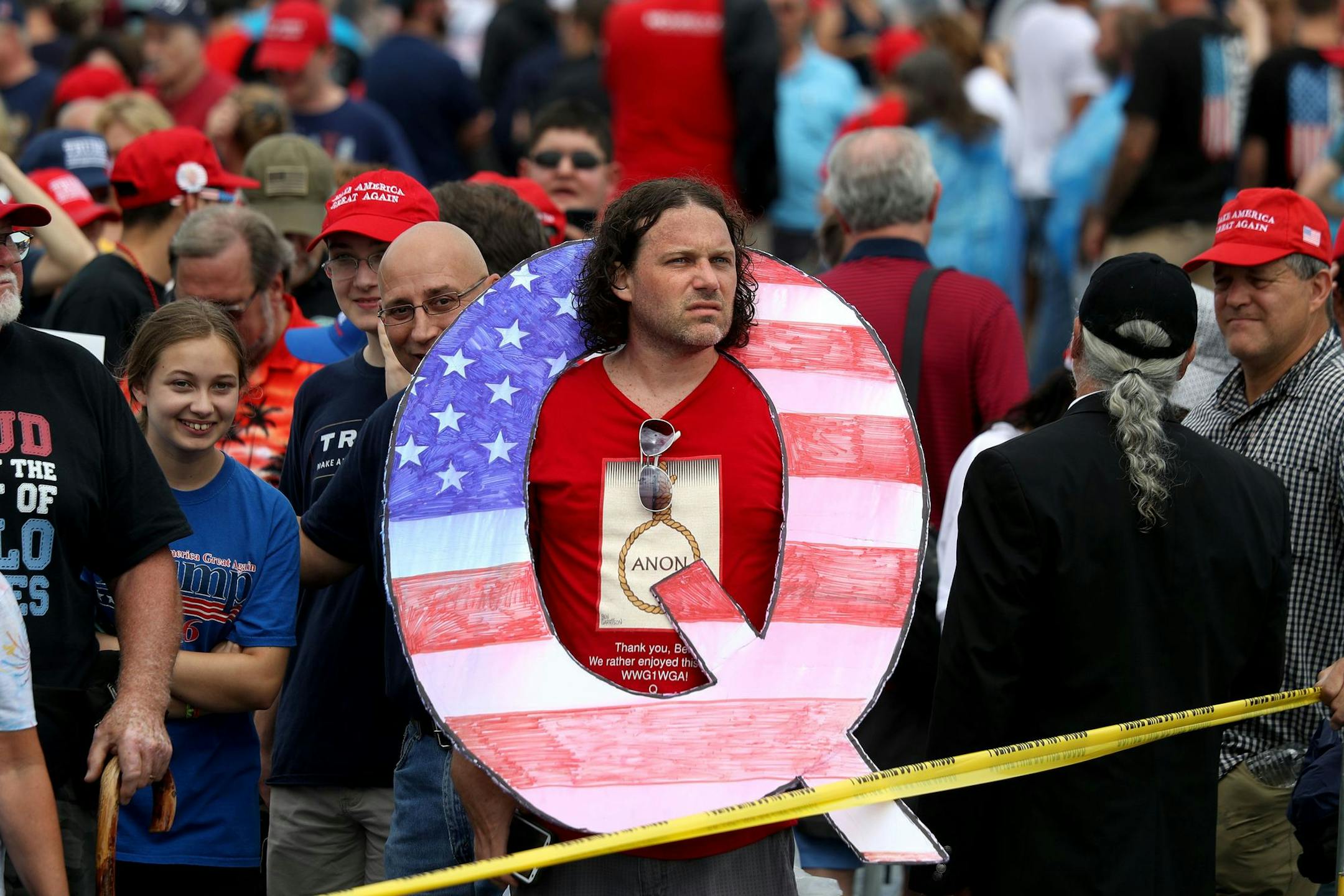 A supporter of President Donald Trump holds up "Q" sign while waiting in line on to see Trump at an August 2018 rally in Pennsylvania. "Q" represents QAnon, a conspiracy theory group.