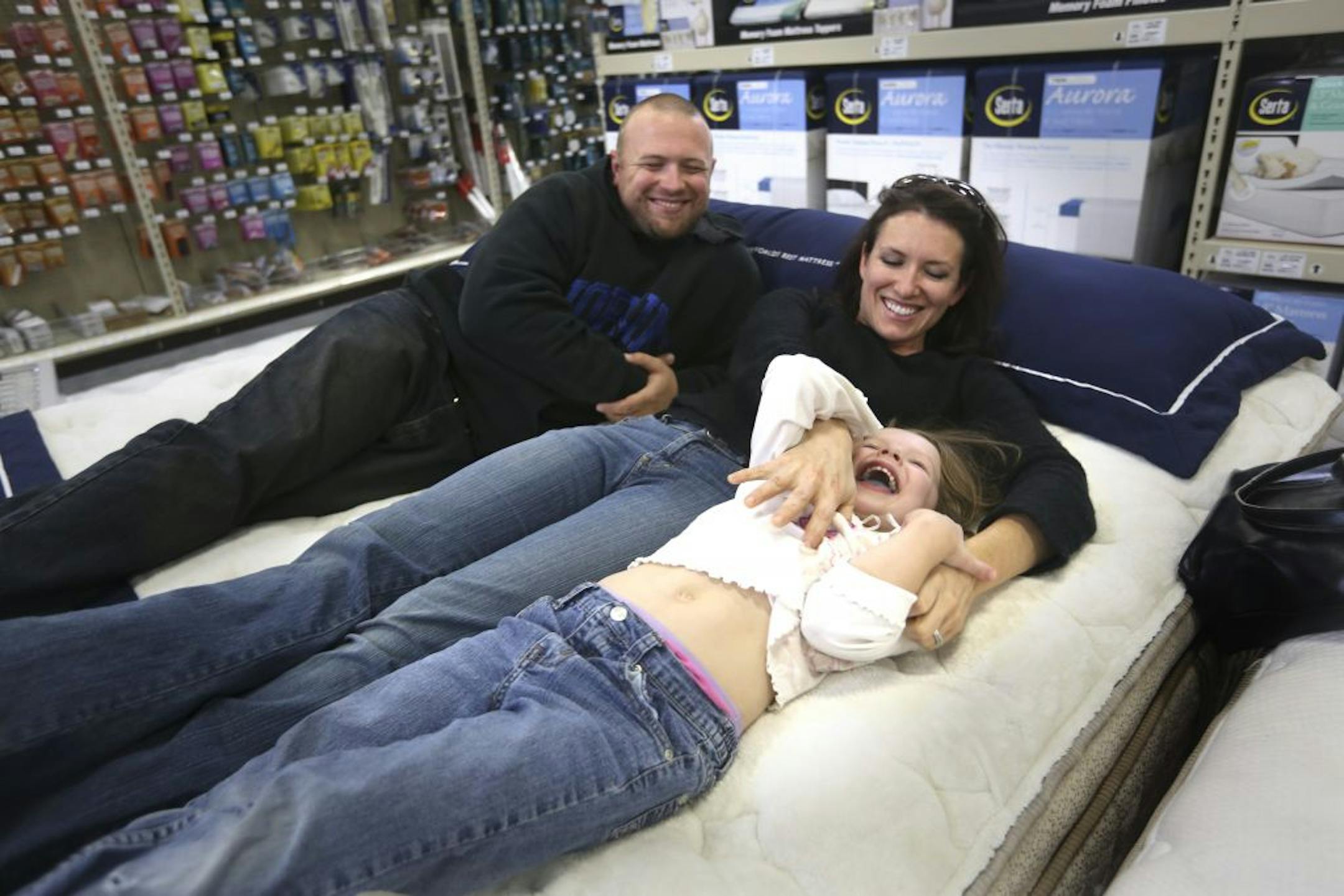 Jenifer Teachey, of Plymouth, with her husband, Ryan Mosman, and daughter Aubrey, 5, tested out the Serta Perfect Sleeper Excalibur at the Golden Valley Menards last week. Teachey said they saw a Menards mattress ad and "this was the main reason why we came today."