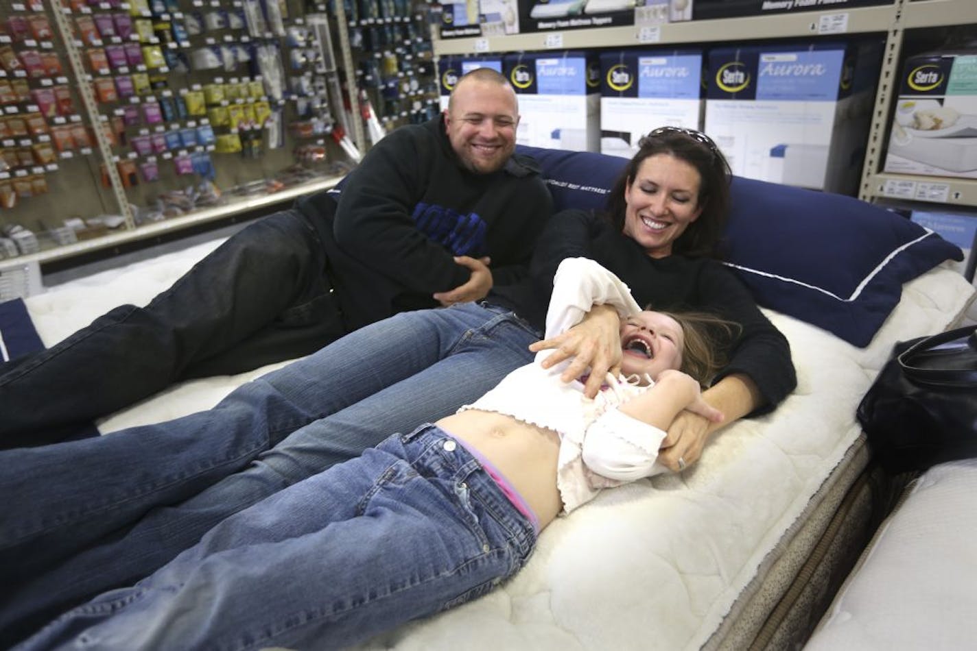 Jenifer Teachey, of Plymouth, with her husband, Ryan Mosman, and daughter Aubrey, 5, tested out the Serta Perfect Sleeper Excalibur at the Golden Valley Menards last week. Teachey said they saw a Menards mattress ad and "this was the main reason why we came today."