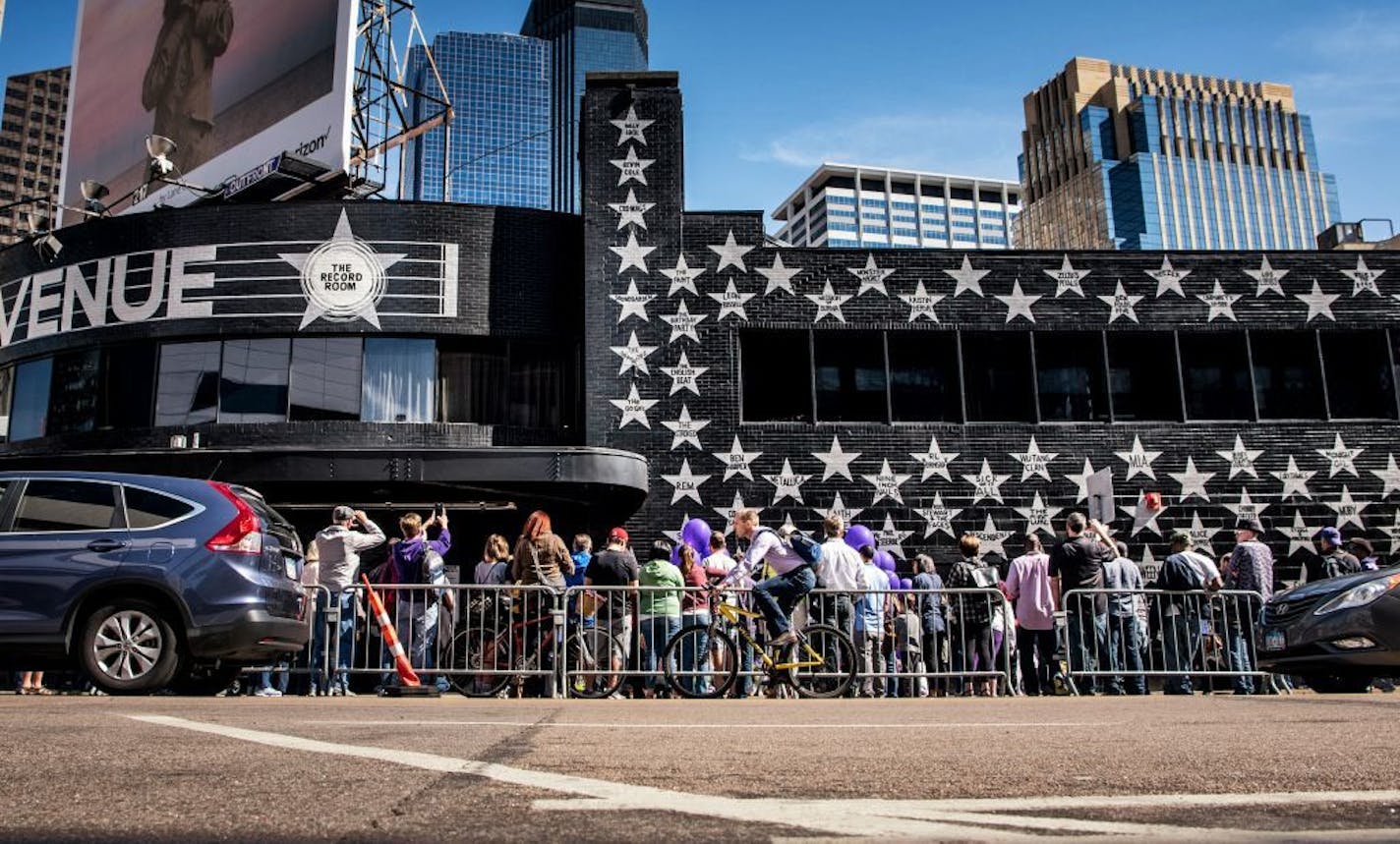 People filed past the makeshift memorial next to Prince's star on First Avenue's wall of stars. They took photos and posed for their own, left letters, purple flowers and balloons. Music by Prince blared from the speakers of passing cars.