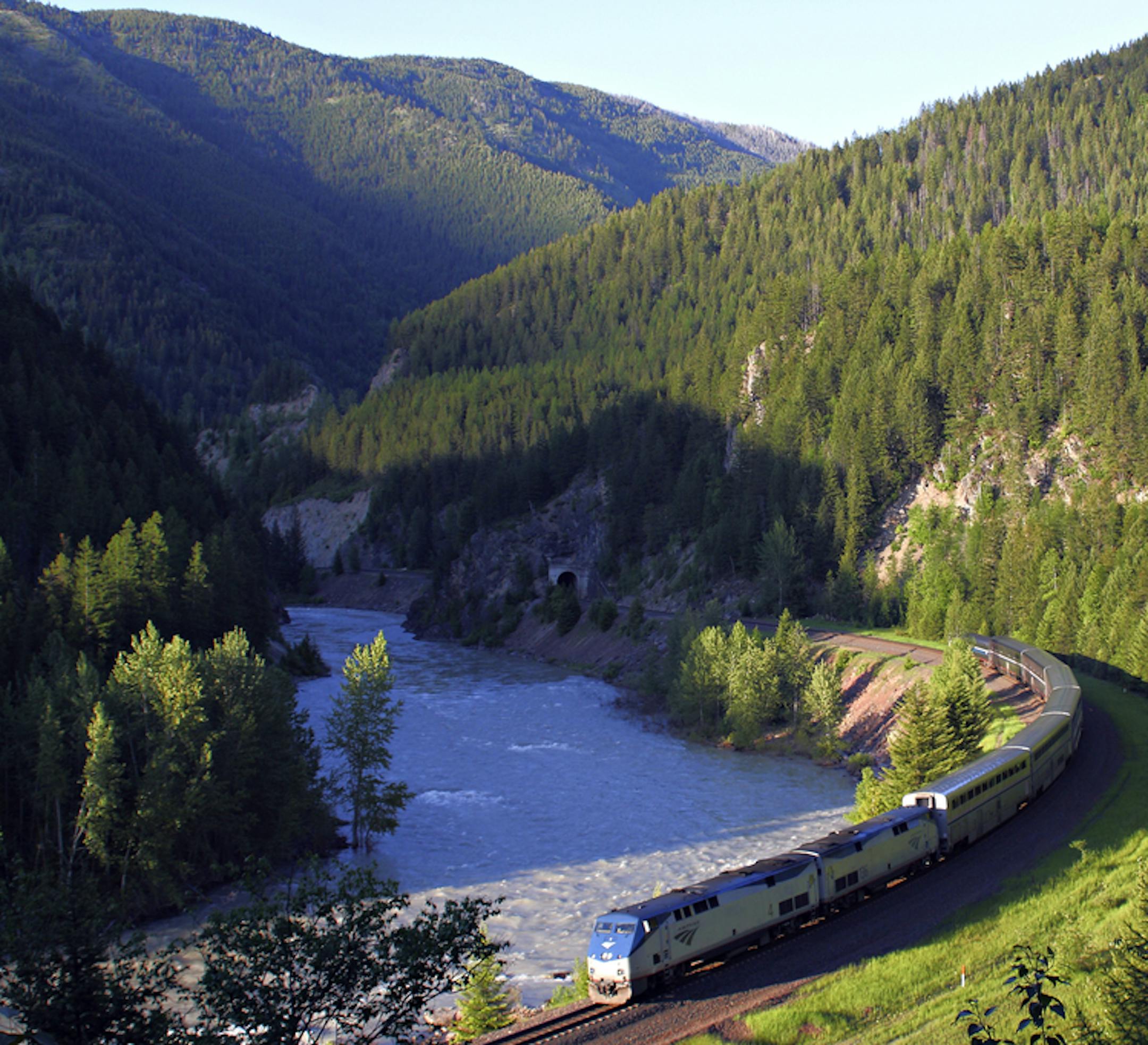 FILE - In this June 26, 2011 file photo, Amtrak's Empire Builder makes its way along the southern boundary of Glacier National Park near West Glacier, Mont. The park, accessible by Amtrak's Empire Builder passenger train, is home to seemingly endless mountain peaks, waterfalls, valleys, wildflowers and lakes. (Justin Franz/Flathead Beacon via AP)