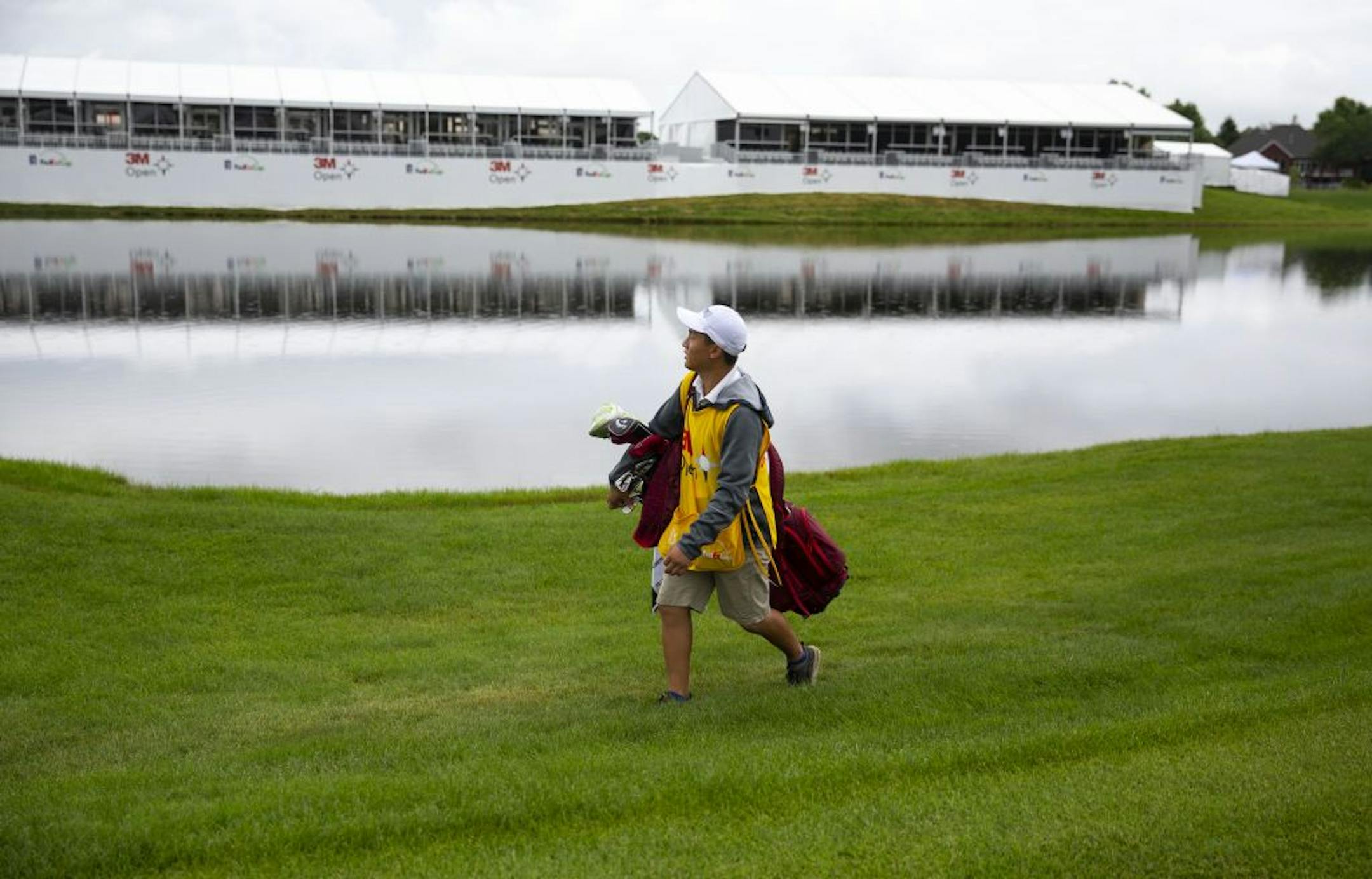 Jacob Roy looked out on the water of the eighteenth hole while caddying for Nikki Jung during a Pro-Am round on Monday. ALEX KORMANN ¥ alex.kormann@startribune.com Caddie U is a local non-profit that trains and places primarily teenage caddies for work at Twin Cities golf clubs. The program is supported by PGA Tour veteran Tim Herron. Jacob Roy had to work two jobs to support himself the last few years but through caddying and Caddie U, was able to pull himself up and receive a partial scholarsh