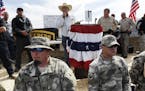 File-This April 12, 2014 file photo shows Rancher Cliven Bundy, center, addressing his supporters along side Clark County Sheriff Doug Gillespie, righ