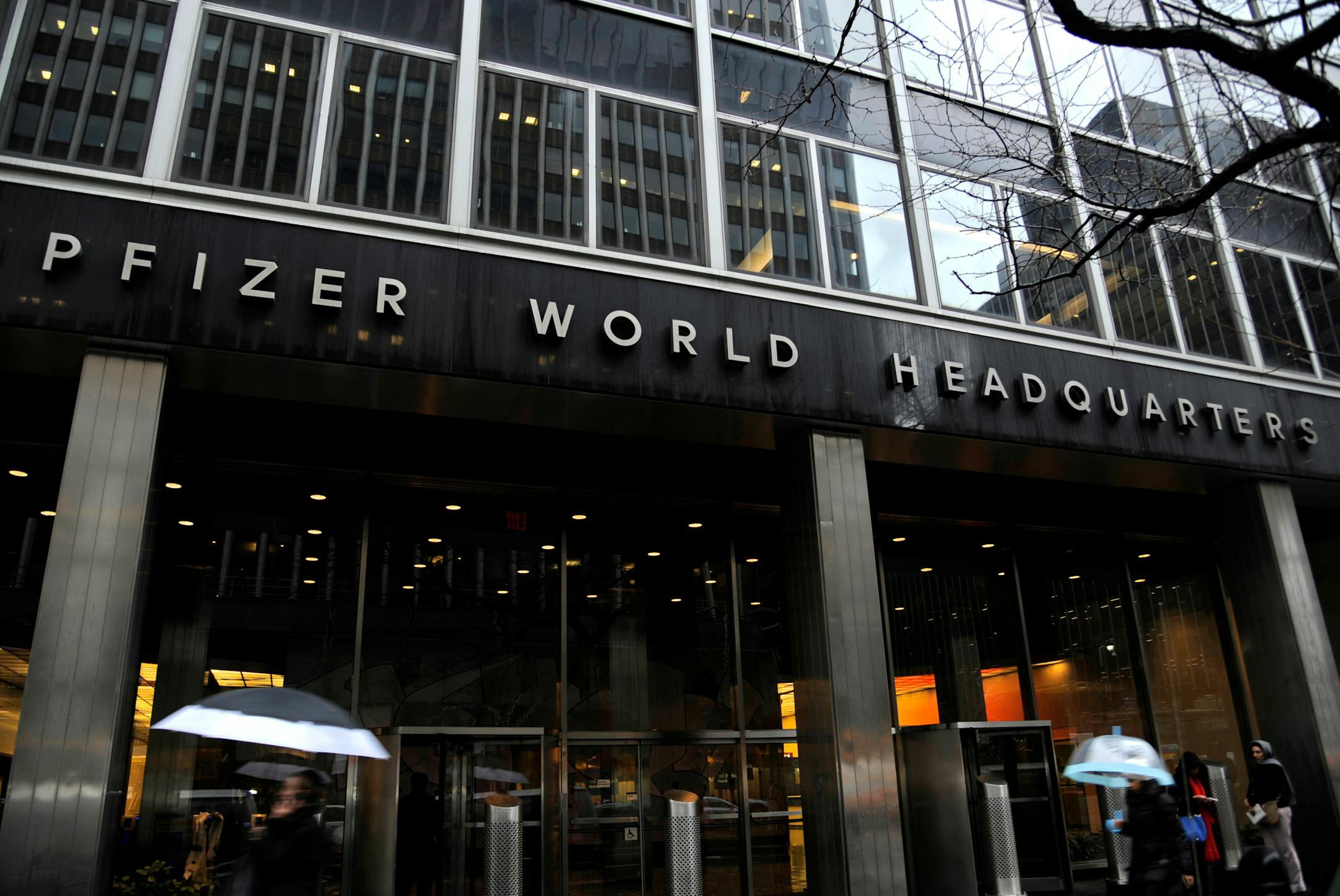 Pedestrians walk past Pfizer Inc. headquarters in New York, U.S., on Friday, Jan. 27, 2012. Pfizer Inc., the world�s largest drugmaker, is scheduled to announce quarterly earnings results on Jan. 31. Photographer: Peter Foley/Bloomberg