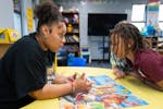 Elsie Carmona Quiterio, an education specialist, works on reading skills with Aasyeya, a first-grade student, at Phelps Recreation Center in Minneapol