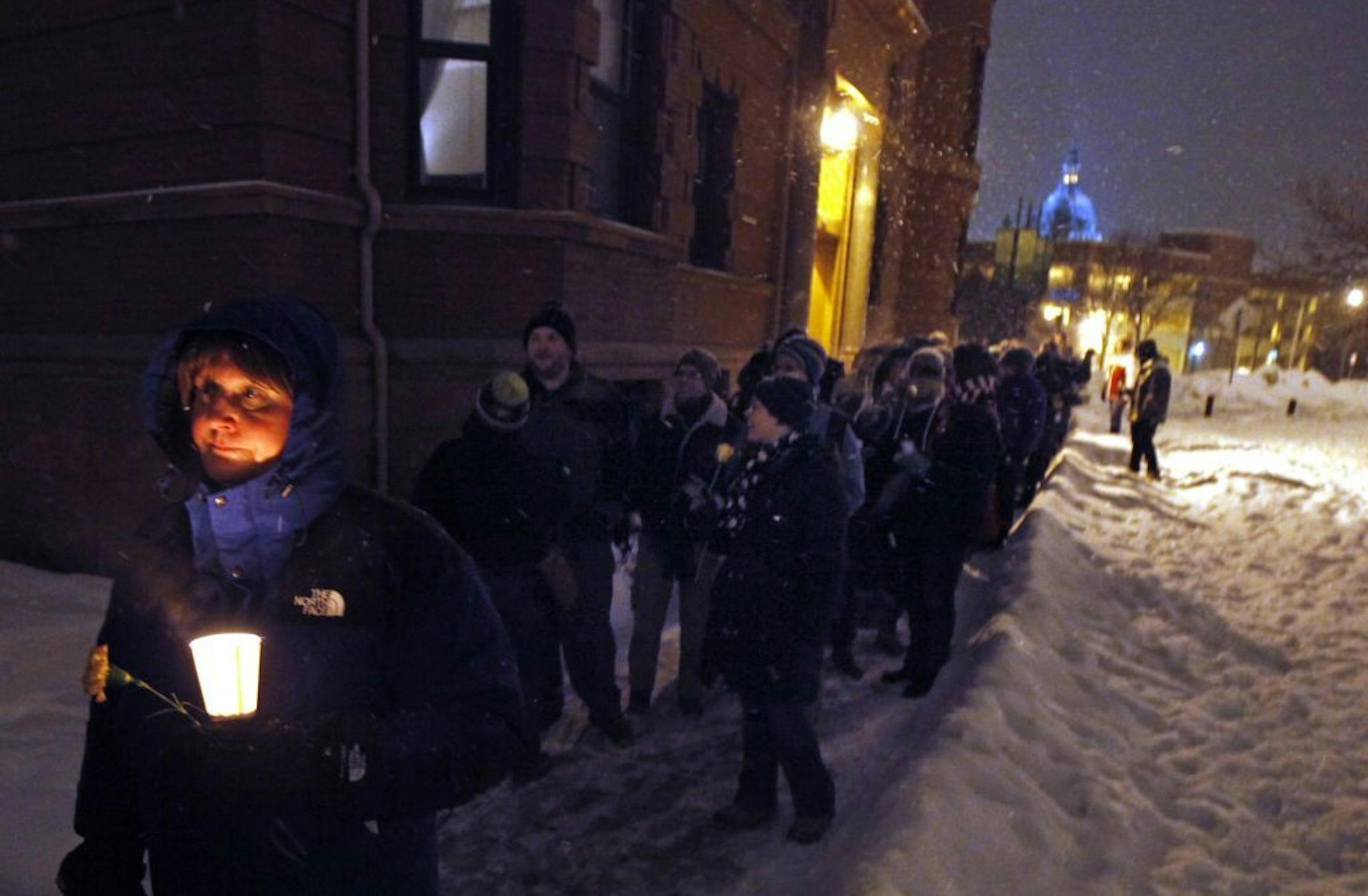 A vigil for Christopher "Krissy" Bates in January. Anne, a transgender woman, held a candle and flower as a large group made their way to Krissy's apartment building near 12th Ave. in Minneapolis during the vigil. Anne said she was afraid to give her last name and didn't know Krissy personally but wanted to show support.
