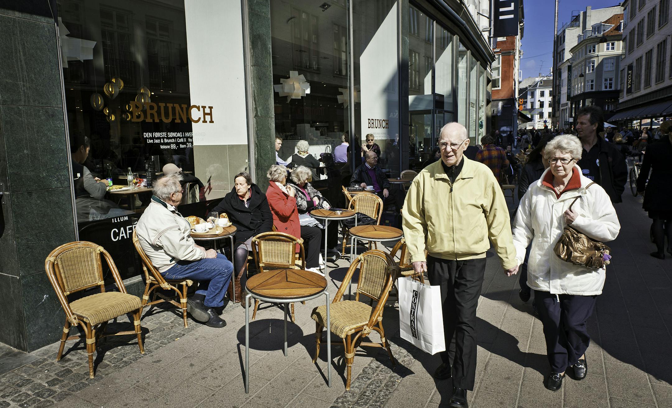 iStockphoto.com
Copenhagen, Denmark - April 15th, 2011: Senior couple strolling through the pedestrianised Stroget shopping district past locals relaxing at pavement cafes on the cobbled street.