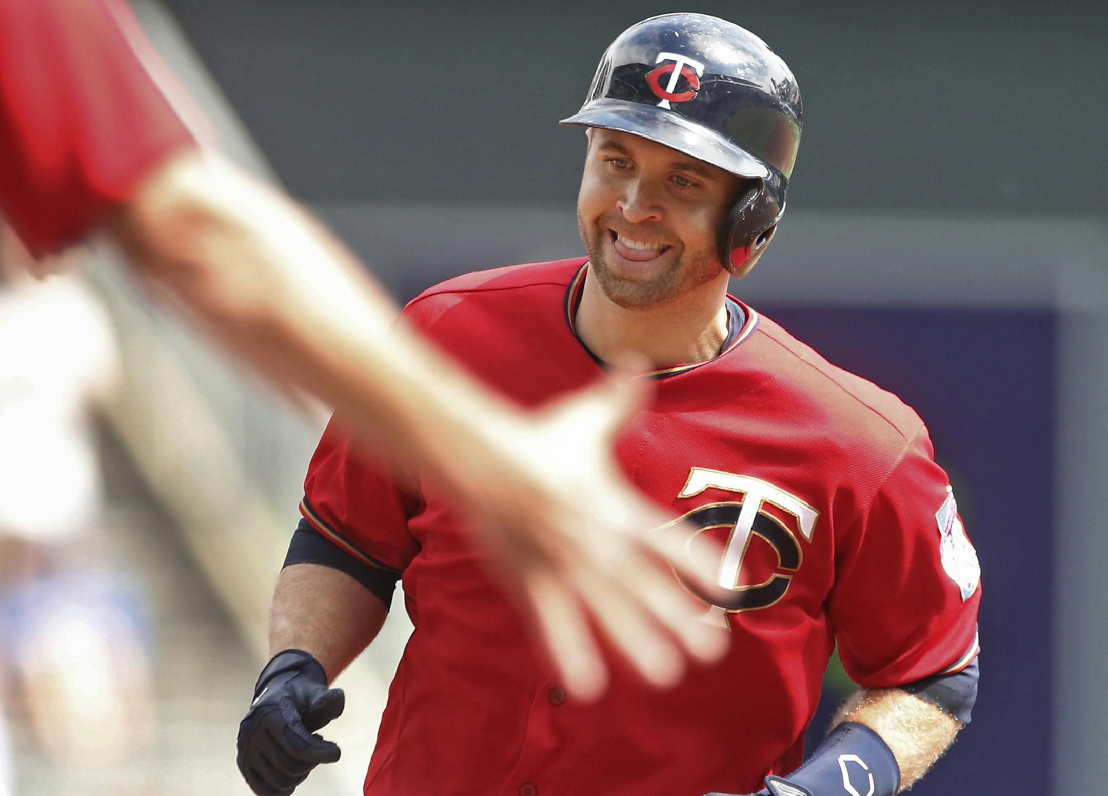 Minnesota Twins' Brian Dozier smiles as the third base coach reaches out to congratulate him as he jogs the base path on a solo home run off Kansas City Royals pitcher Ian Kennedy in the first inning of a baseball game Monday, Sept. 5, 2016, in Minneapolis. (AP Photo/Jim Mone)