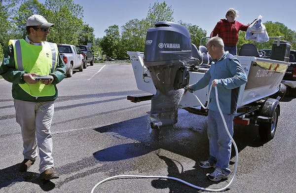 In 1995, the DNR started a system of intermittent, at-the-ramp boat inspections like this one on Lake Minnetonka to thwart aquatic invasive species (A
