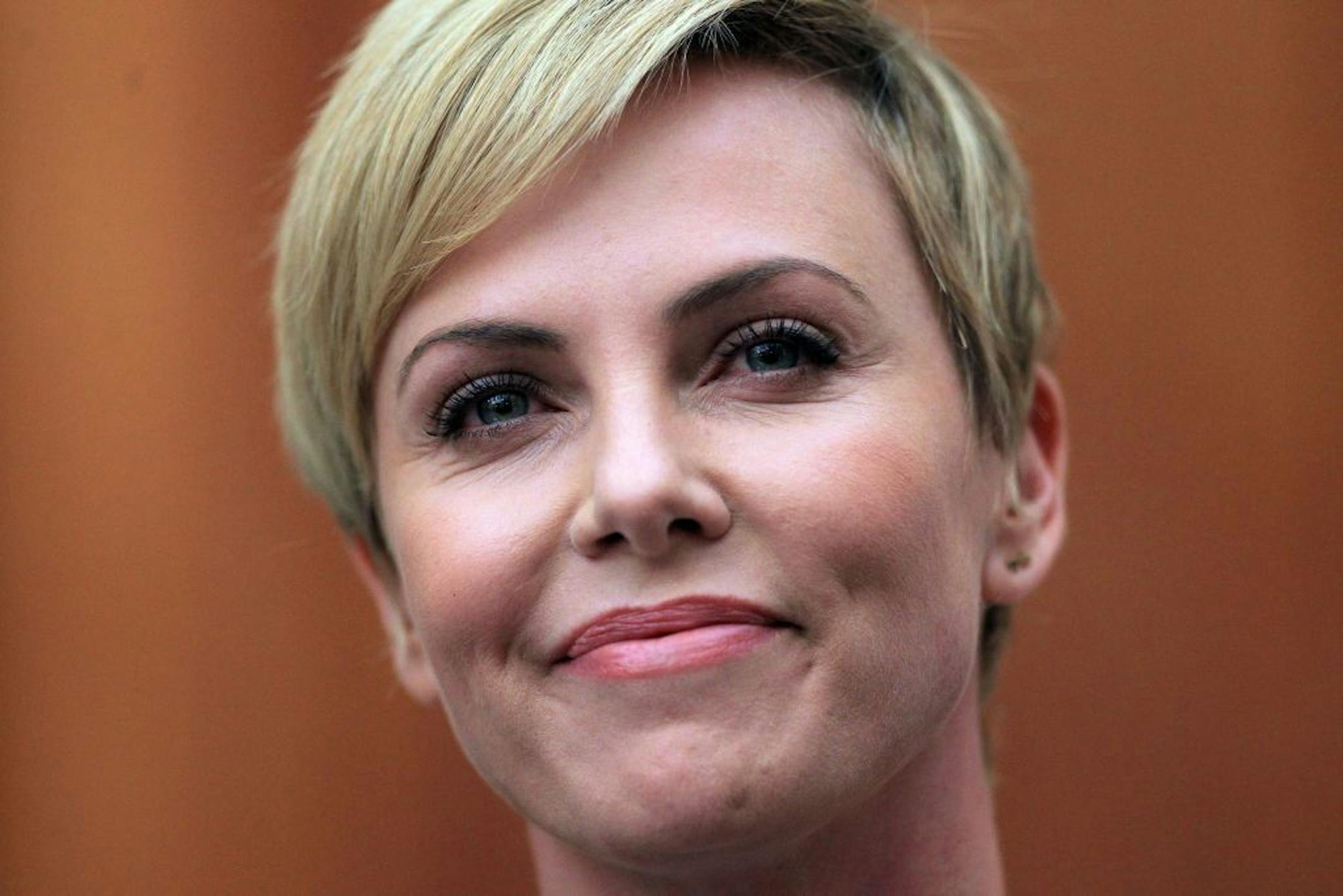 South African-born Hollywood actress Charlize Theron reacts during her joint media conference with South African President Jacob Zuma, unseen, after their meeting at his Union Building office in Pretoria, South Africa, Monday, 29 July 2013. They discussed the fight against HIV and Aids, and "how collaboration can assist mitigate the pandemic's negative impact on young girls".