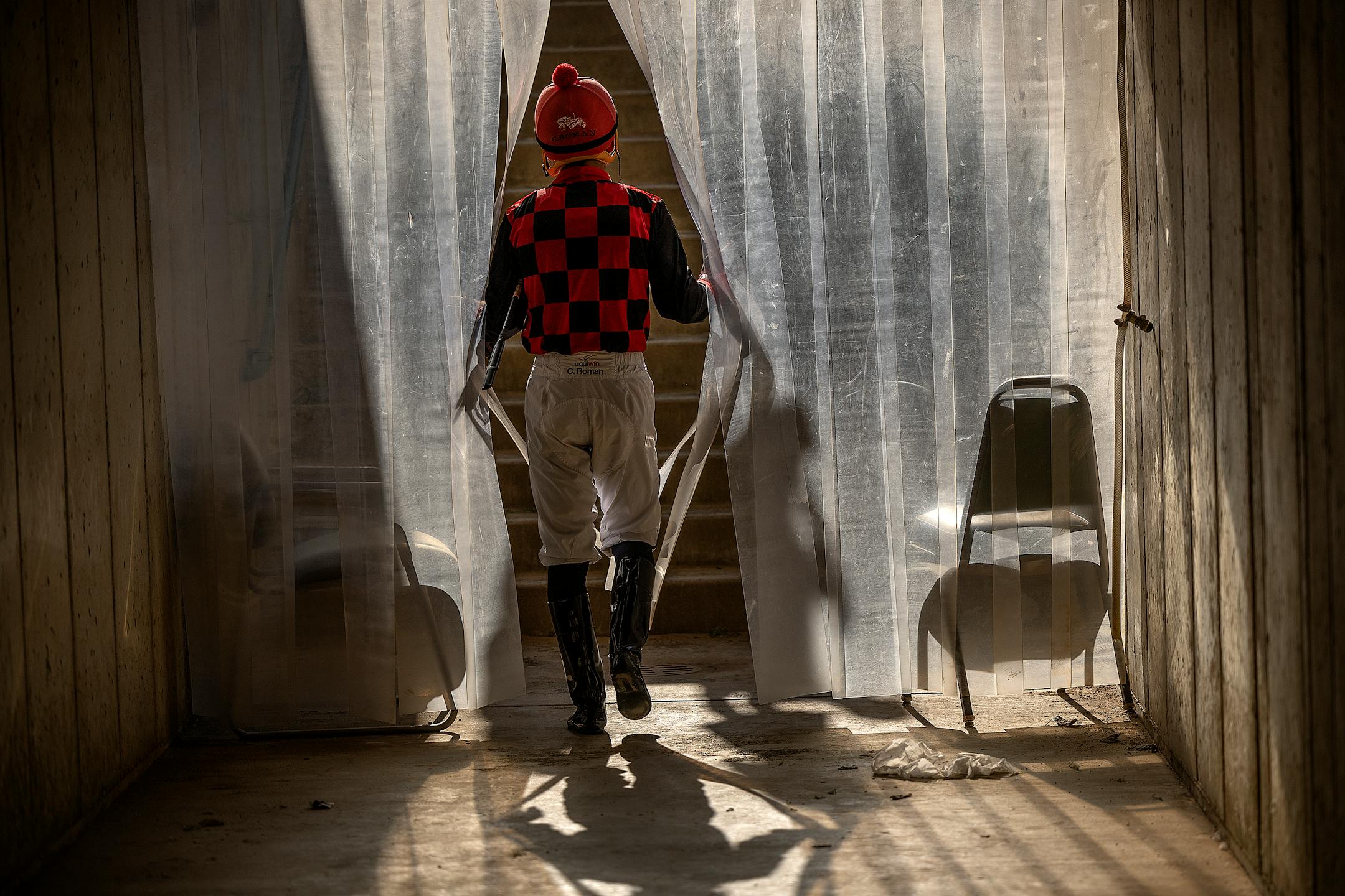 A jockey makes his way onto the paddock on opening night at Canterbury Park in Shakopee, Minn.