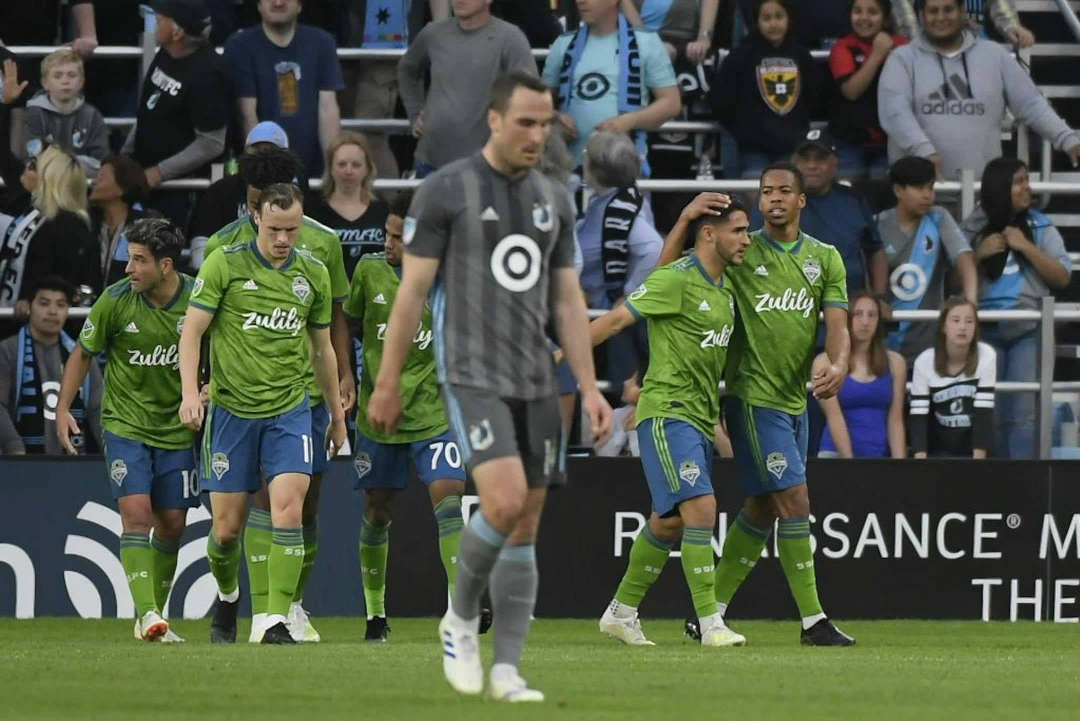 Seattle Sounders midfielder Jordy Delem (21), far right, embraced midfielder Cristian Roldan (7) after Roldan's first half goal against the Minnesota United, tying the game 1-1.