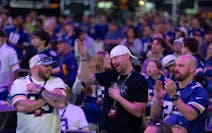 Cody Kraskey, Garret Wright, and Zac Evans, from left, react to the Vikings moving up to the 17th pick and selecting outside linebacker Dallas Turner 