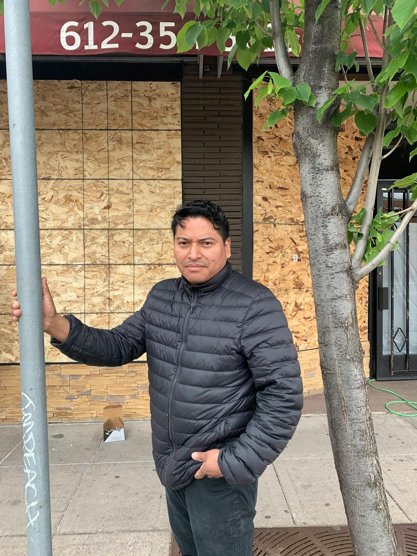 Luis Tamay owns El Chuchi market. He watched the o'reilly auto parts store fire across the street last night, praying the flames didn't reach his business. He's putting more boards up to protect his business tonight.