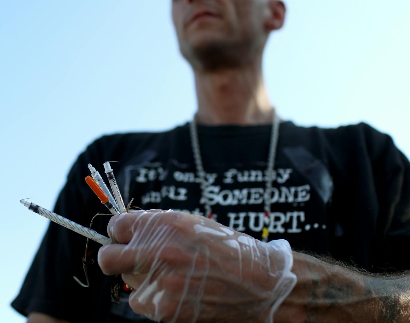 A man collected discarded syringes as nearby a dinner line sponsored by Natives Against Heroin was being held at a homeless encampment near Hiawatha and Cedar Avenues Wednesday, Aug. 8, 2018, in Minneapolis, MN.] DAVID JOLES ï david.joles@startribune.com
Tensions are building over a large and growing homeless encampment near the Little Earth housing complex in south Minneapolis. Native leaders and homeless outreach workers are frustrated over the city's repeated attempts to clear out the encampm