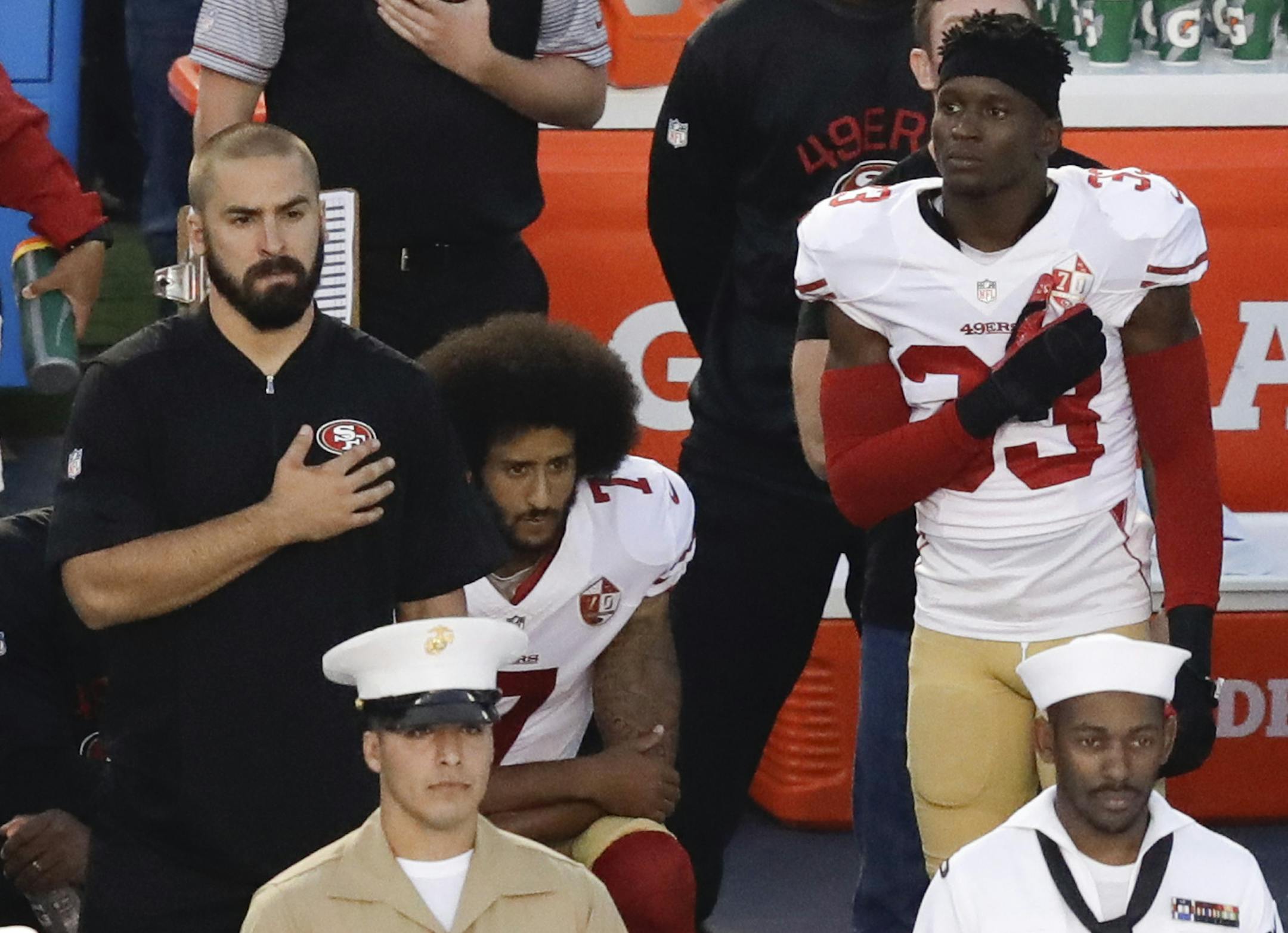 San Francisco 49ers quarterback Colin Kaepernick, middle, sits during the national anthem before an NFL preseason football game against the San Diego Chargers, Thursday, Sept. 1, 2016, in San Diego. (AP Photo/Chris Carlson)