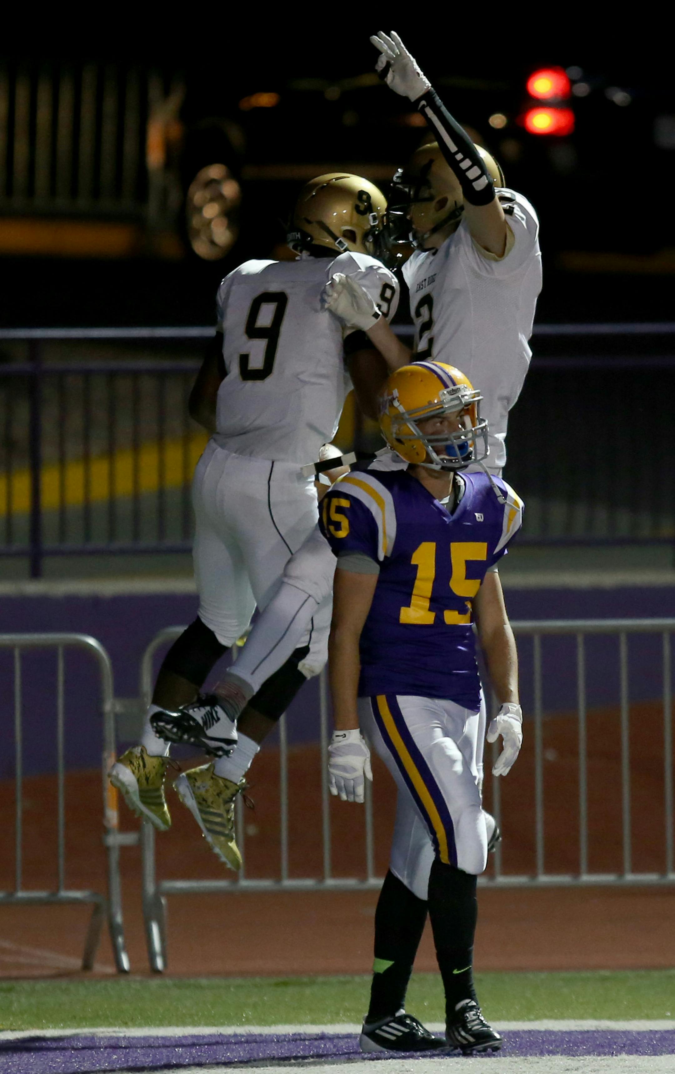 East Ridge's Kjetll Cline celebrated with teammate Bobby Remke after scoring a touchdown being defended by Cretin-Derham Hall's Connor Fitzgerald in the first half. ] (KYNDELL HARKNESS/STAR TRIBUNE) kyndell.harkness@startribune.com Cretin-Derham Hall vs East Ridge in St. Paul Min., Friday, August, 5, 2014.