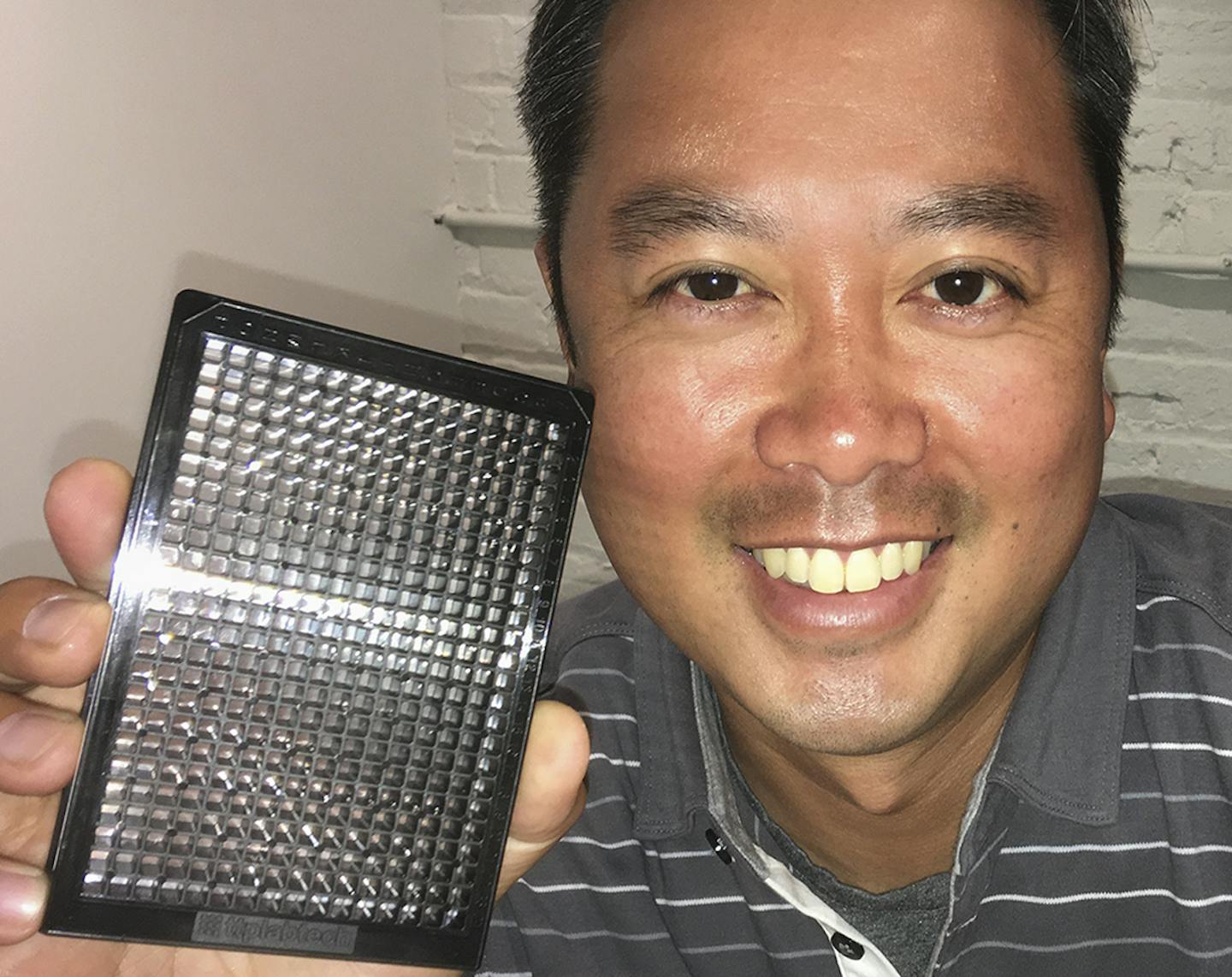 StemoniX cofounder Ping Yeh holds up a device made by his company that grows small &#xec;wells&#xee; of raw brain and heart cells from stem cells. These &#xec;MicroOrgans,&#xee; used in drug screening, are made from stem cells cultured from a patient&#xed;s own skin or blood. ] Photo by Joe Carlson 1004079213 WHITEBOARD070917