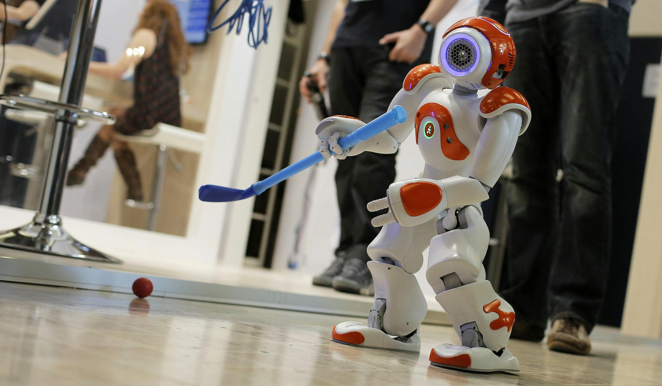 The NAO humanoid robot plays golf during the Innorobo European summit, an event dedicated to the service robotics industry, in Lyon, central France, Thursday, March 20, 2014. (AP Photo/Laurent Cipriani)