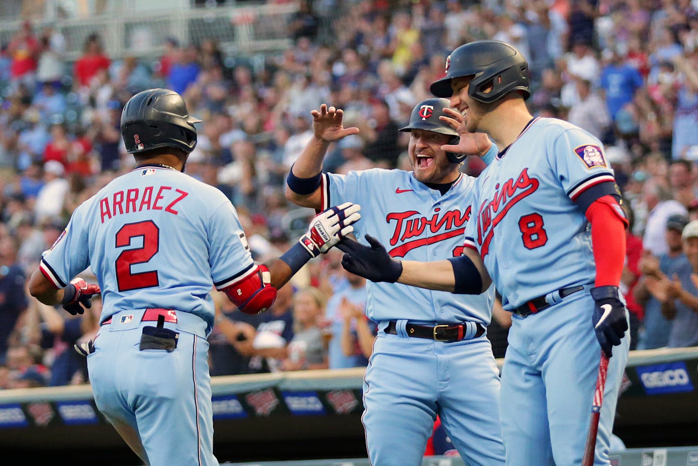 Minnesota Twins' Luis Arraez (2) is congratulated by teammates Josh Donaldson (20) and Mitch Garver (8) after Arraez's home run against the Tampa Bay Rays in the third inning of a baseball game, Saturday, Aug. 14, 2021, in Minneapolis. (AP Photo/Andy Clayton-King)