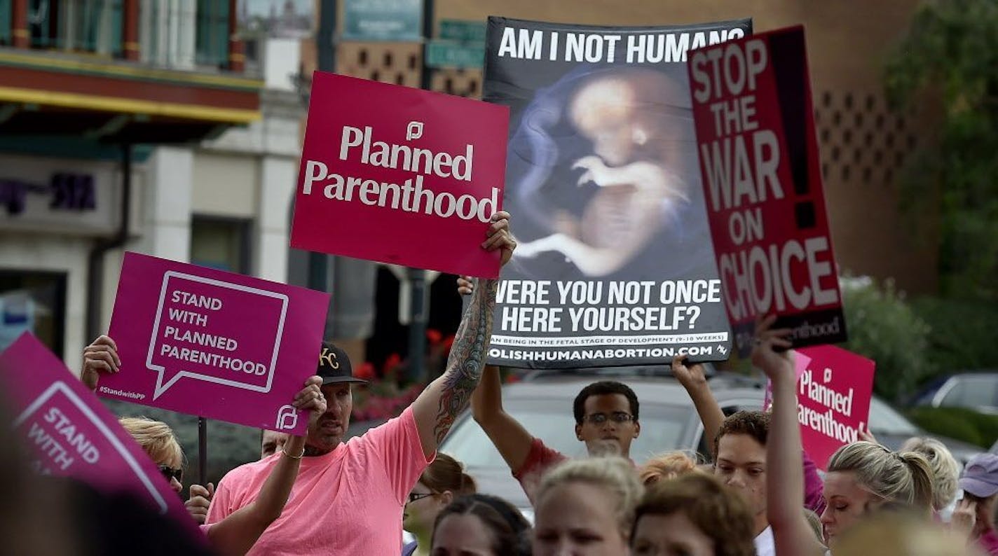 FILE -- An anti-abortion demonstrator held up a sign as supporters of Planned Parenthood rallied in Kansas City, Mo., in September 2015.