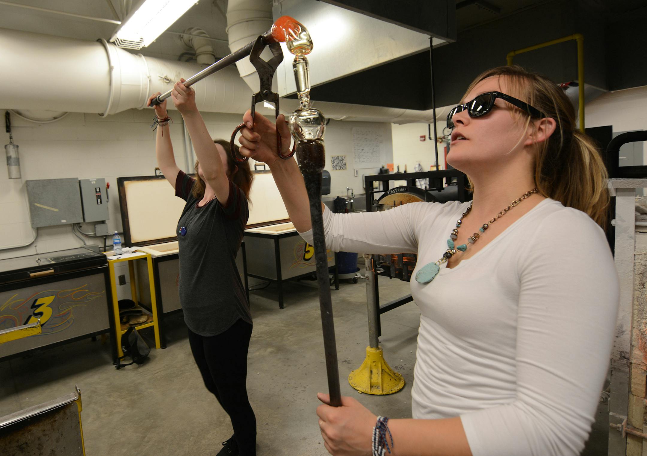 Anoka-Ramsey Community College seniors Andi Rain and Heather Hauta work on a goblet in the glassblowing studio. Photo by Liz Rolfsmeier, Special to the Star Tribune